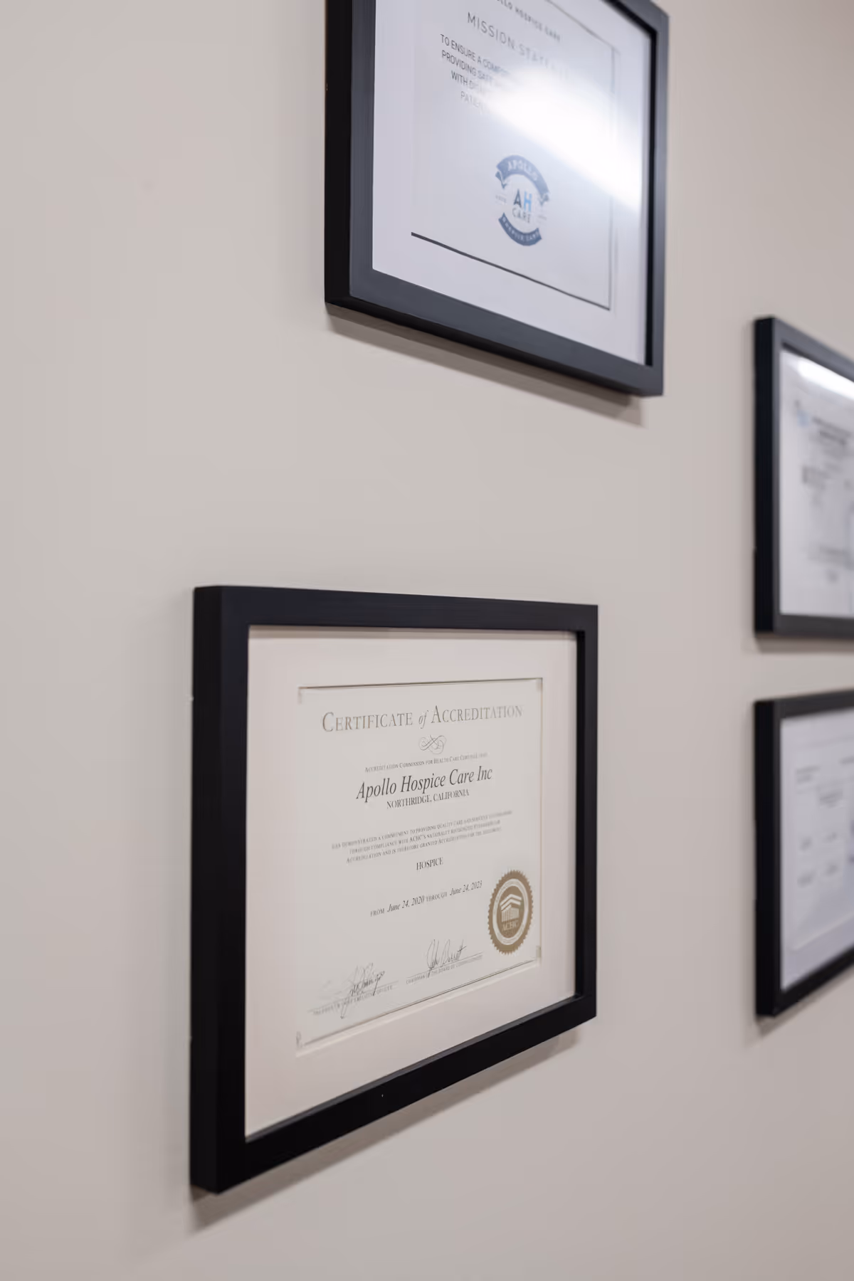 Wall with framed certificates hanging in a hallway of Apollo Hospice Care.