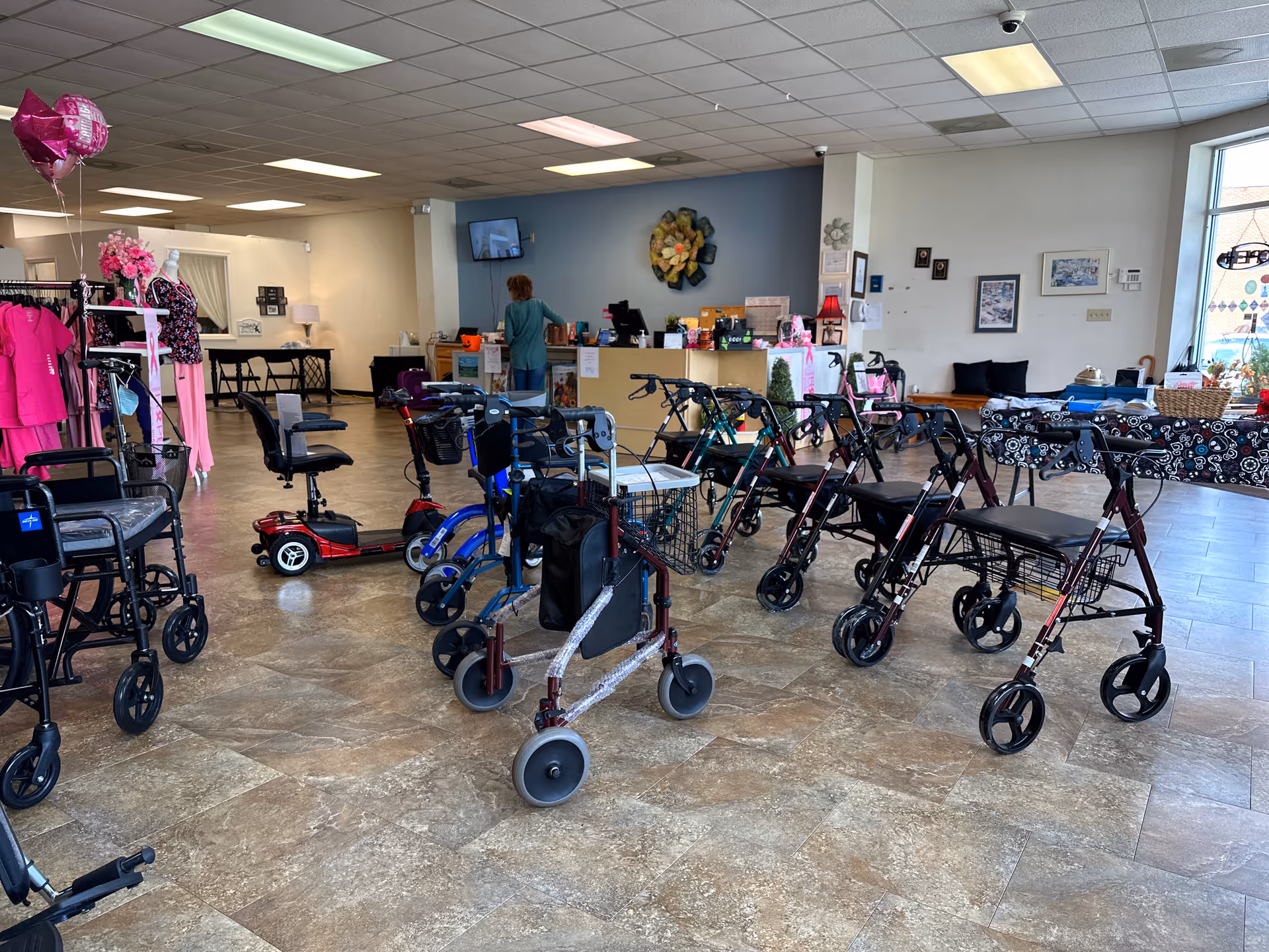 Interior showroom with walkers, wheelchairs, and other mobility aids near a reception desk.