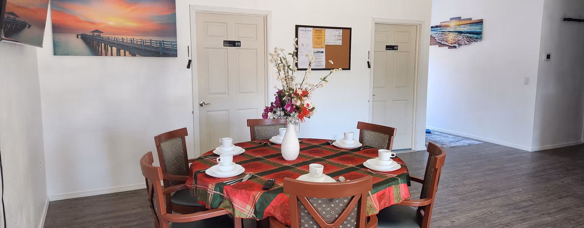 Round dining table set with cups and a floral centerpiece.