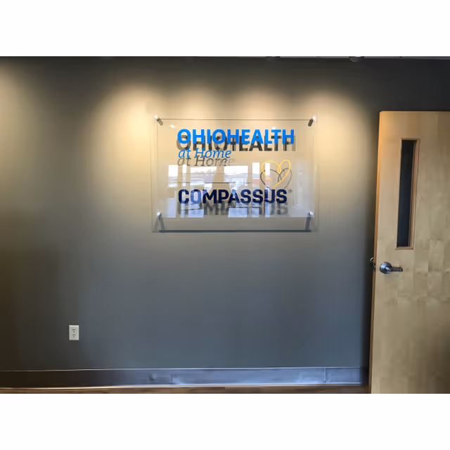 Interior wall with glass plaque displaying OhioHealth at Home Compassus sign and doorway.