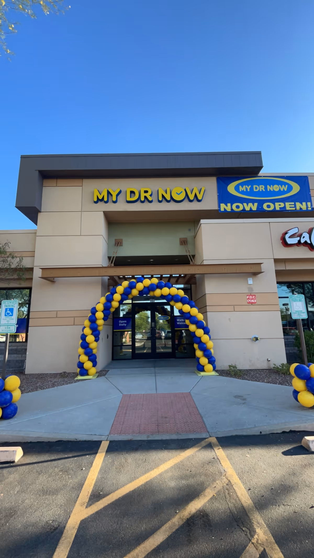 Front entrance of MY DR NOW with blue-yellow balloon arch and signage