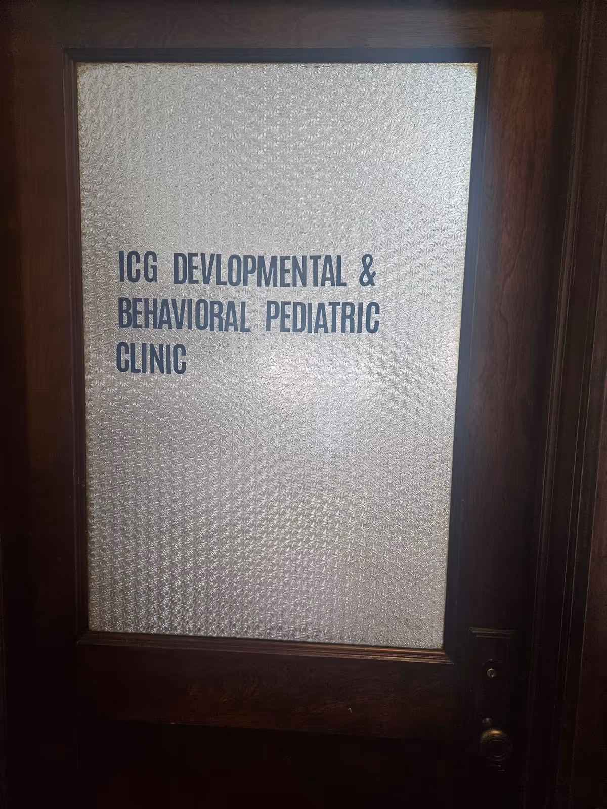 Door with frosted glass panel displaying ICG Developmental & Behavioral Pediatric Clinic