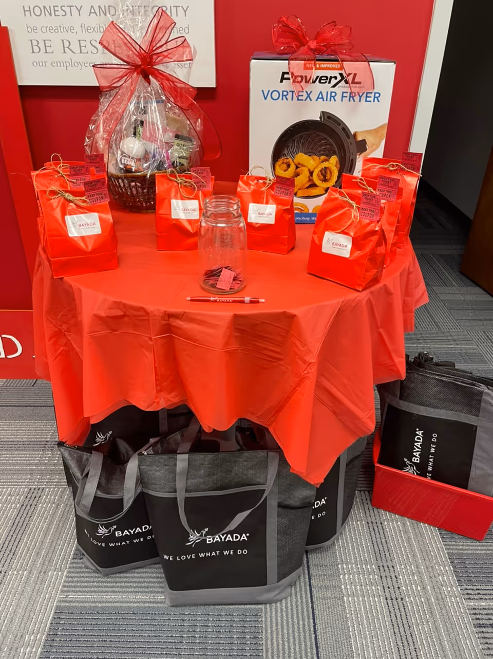Round table with red gift bags and a Vortex Air Fryer box.