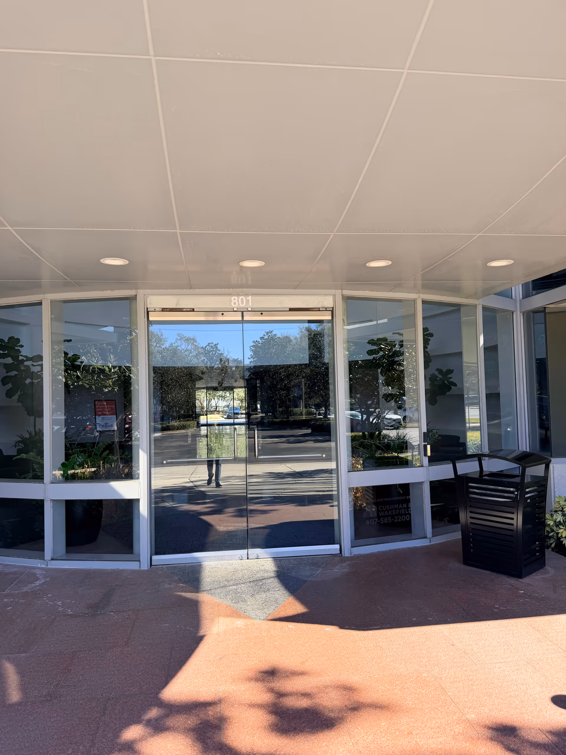 Entrance of Amada Senior Care building with glass doors and planters.