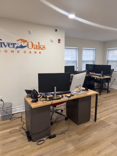 Office area inside River Oaks Home Care with desks, computers, and office equipment.