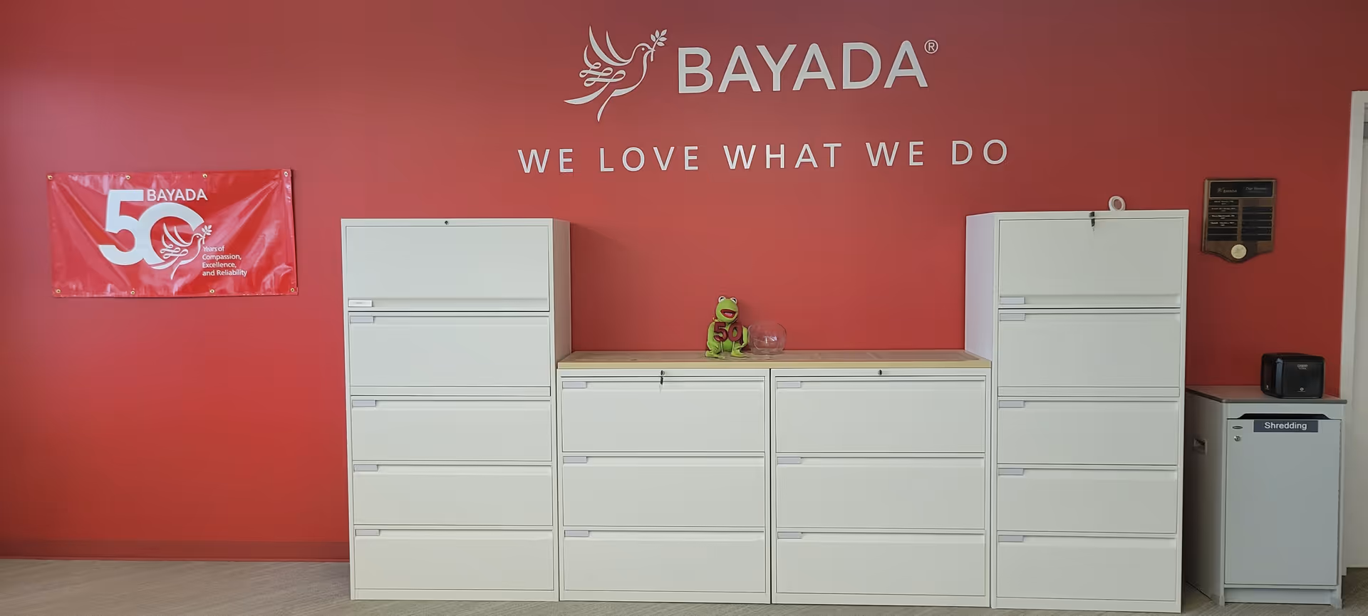 Interior reception area featuring white filing cabinets against a red BAYADA wall.