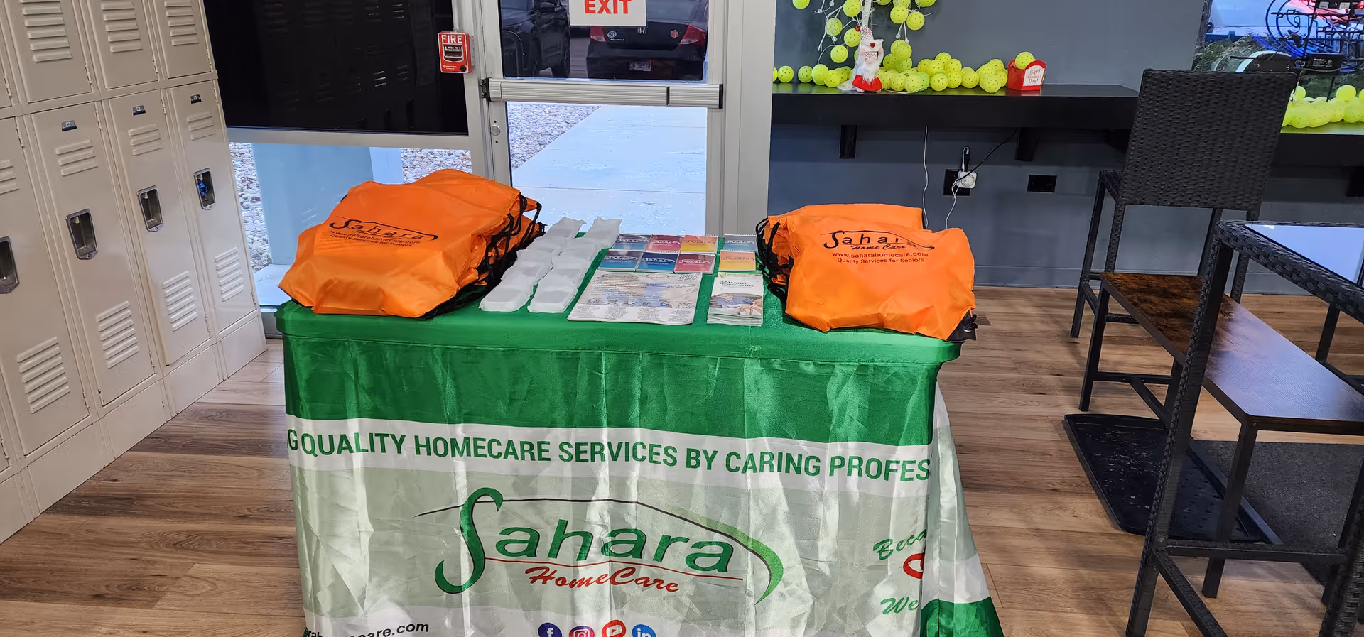 Indoor lobby with lockers and a Sahara Home Care promotional table.