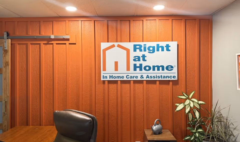 Interior office lobby with orange paneled wall and Right at Home sign.