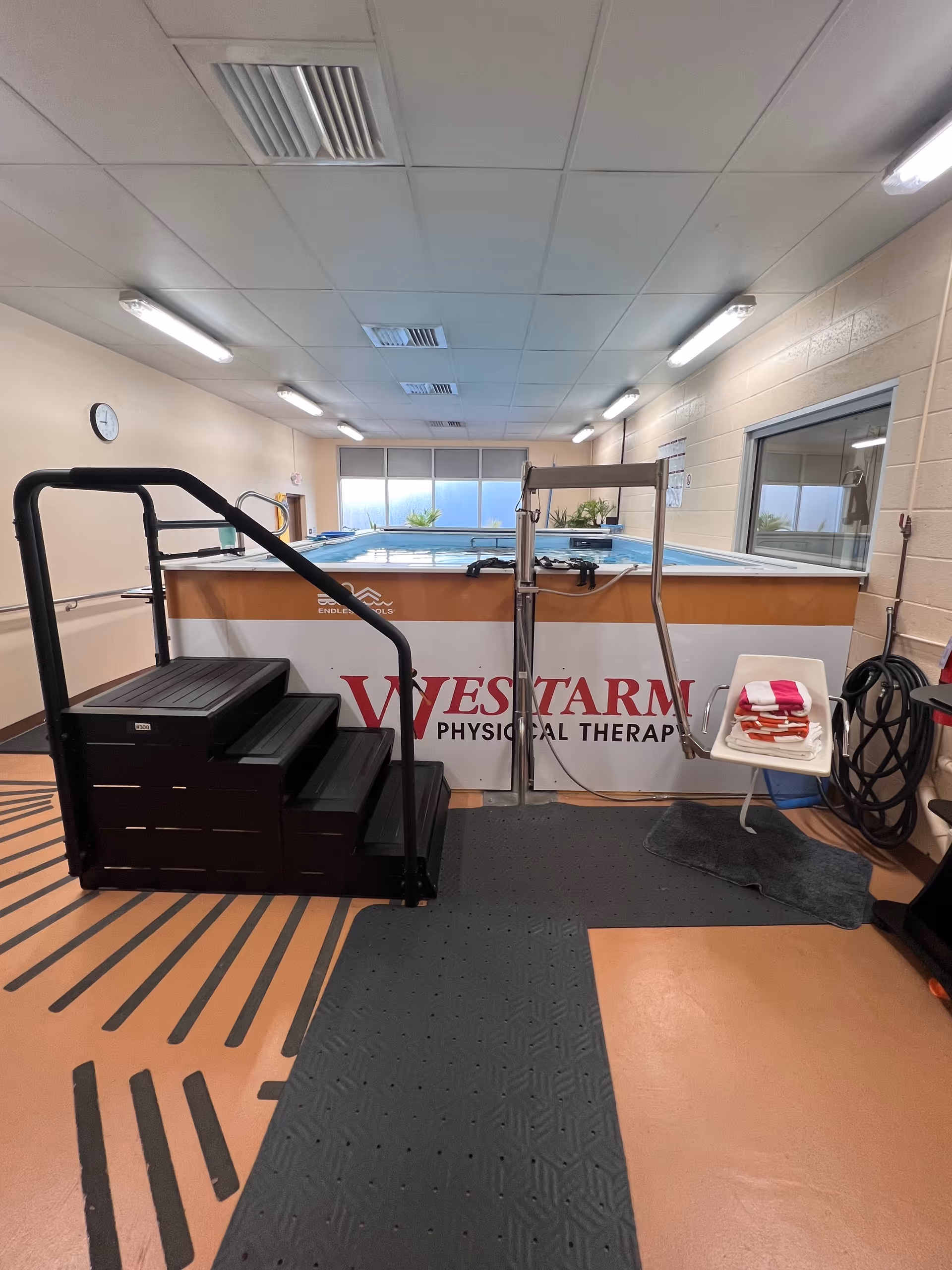 Indoor pool therapy area with stairs and railing inside a WESTARM facility.