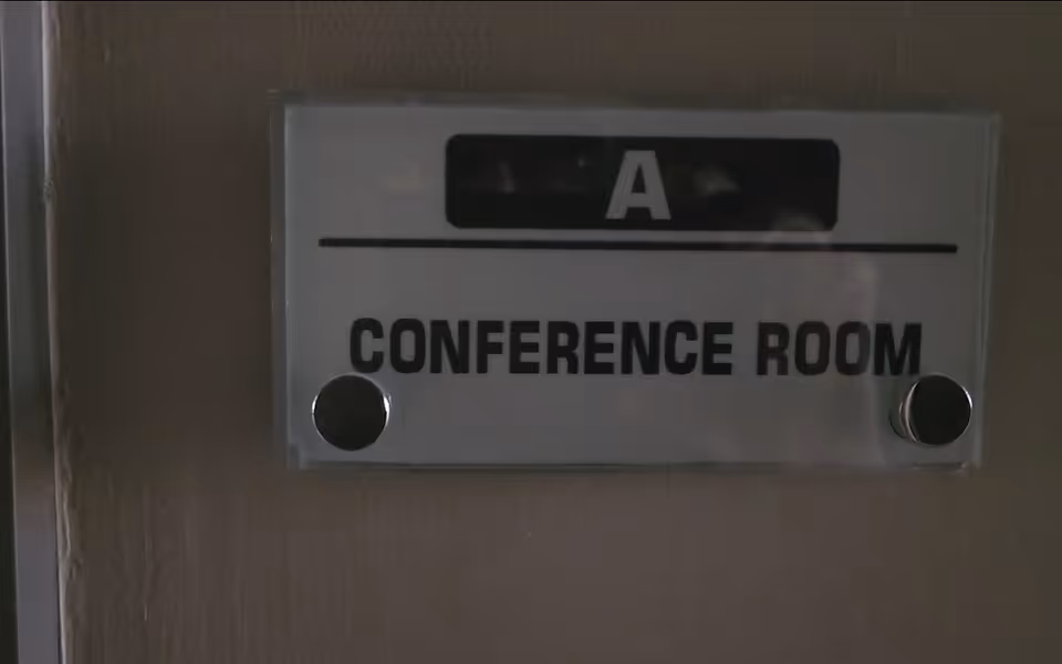 Metal conference room sign on wall reads 'A CONFERENCE ROOM'.
