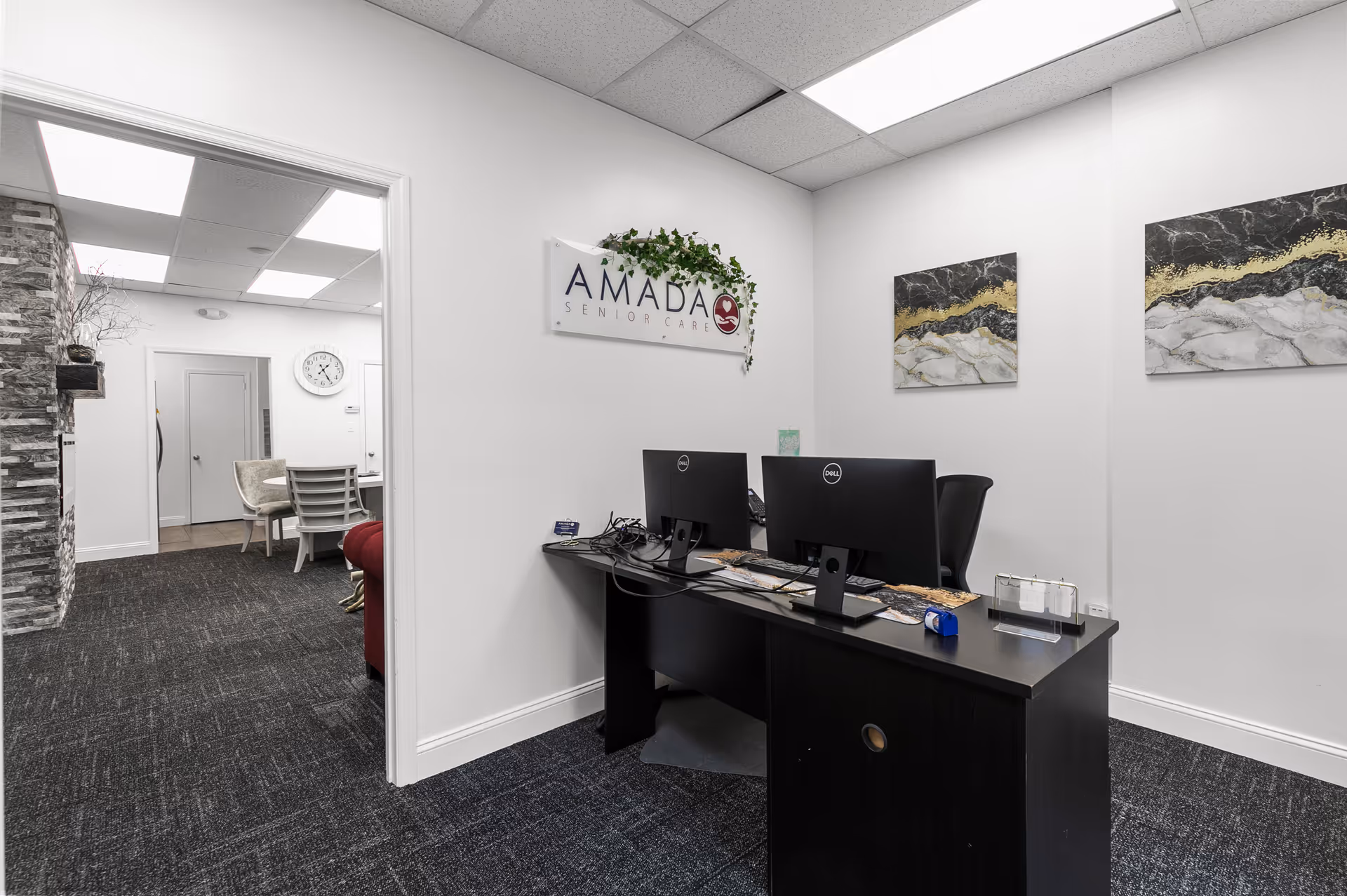Reception desk with two computer monitors inside Amada Senior Care facility lobby