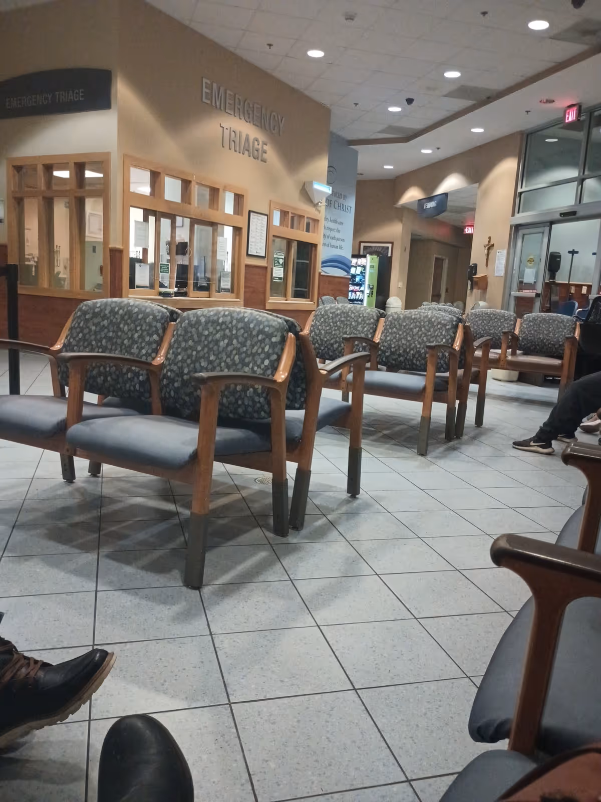 Waiting area inside a medical center with rows of patterned chairs.