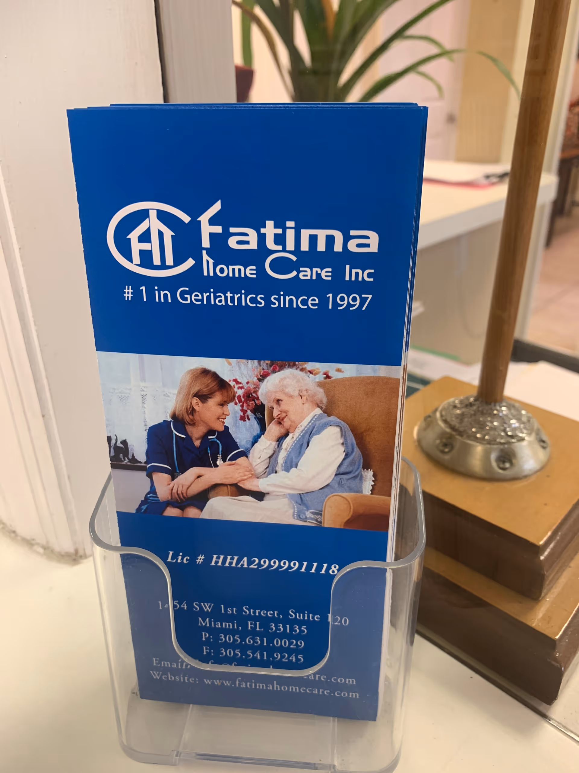 Blue Fatima Home Care brochure in a clear acrylic rack on a desk.
