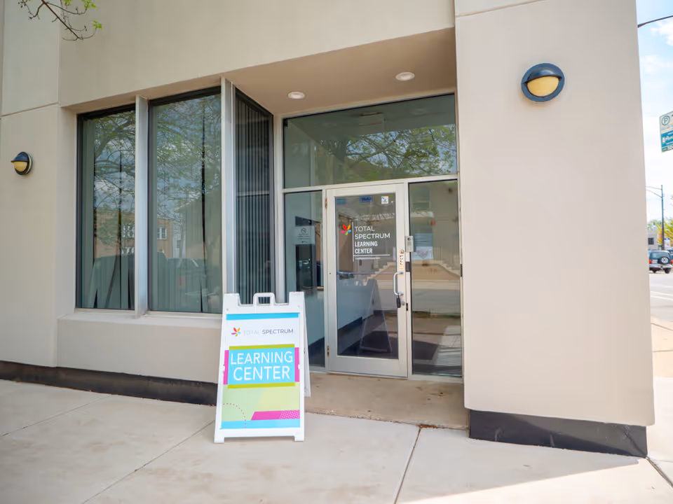 Exterior view of a Total Spectrum ABA building entrance with a colorful Learning Center sign