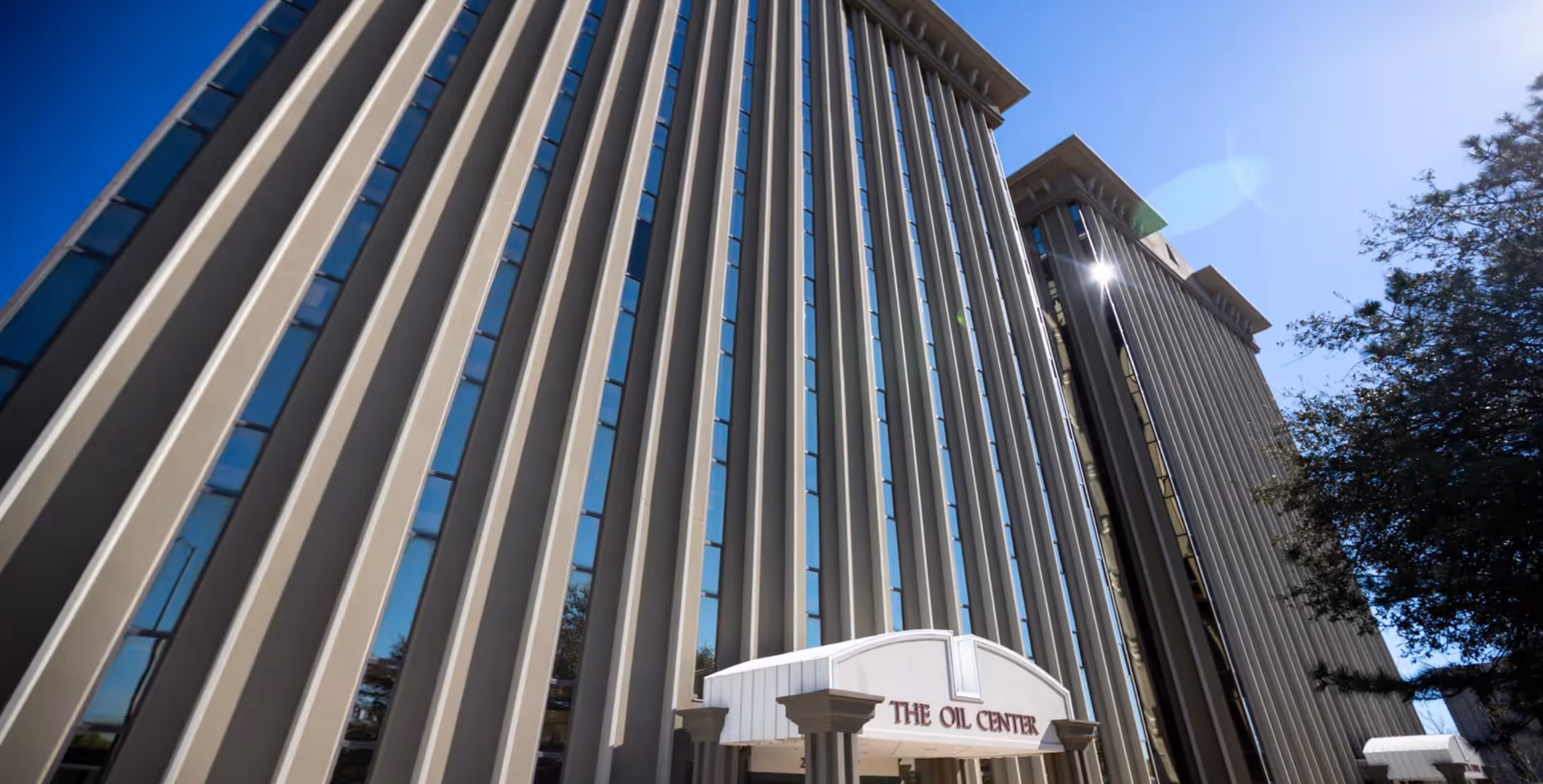 Tall modern senior living facility exterior with entrance canopy.