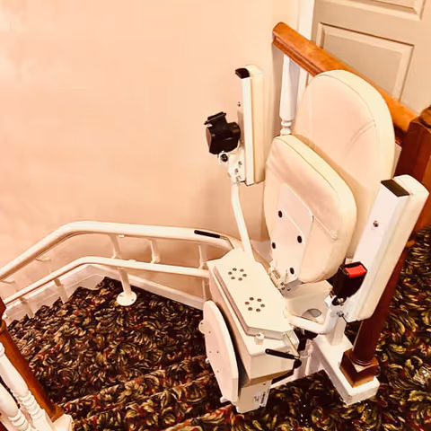 Interior stairway with a mounted chair stairlift along the railing.