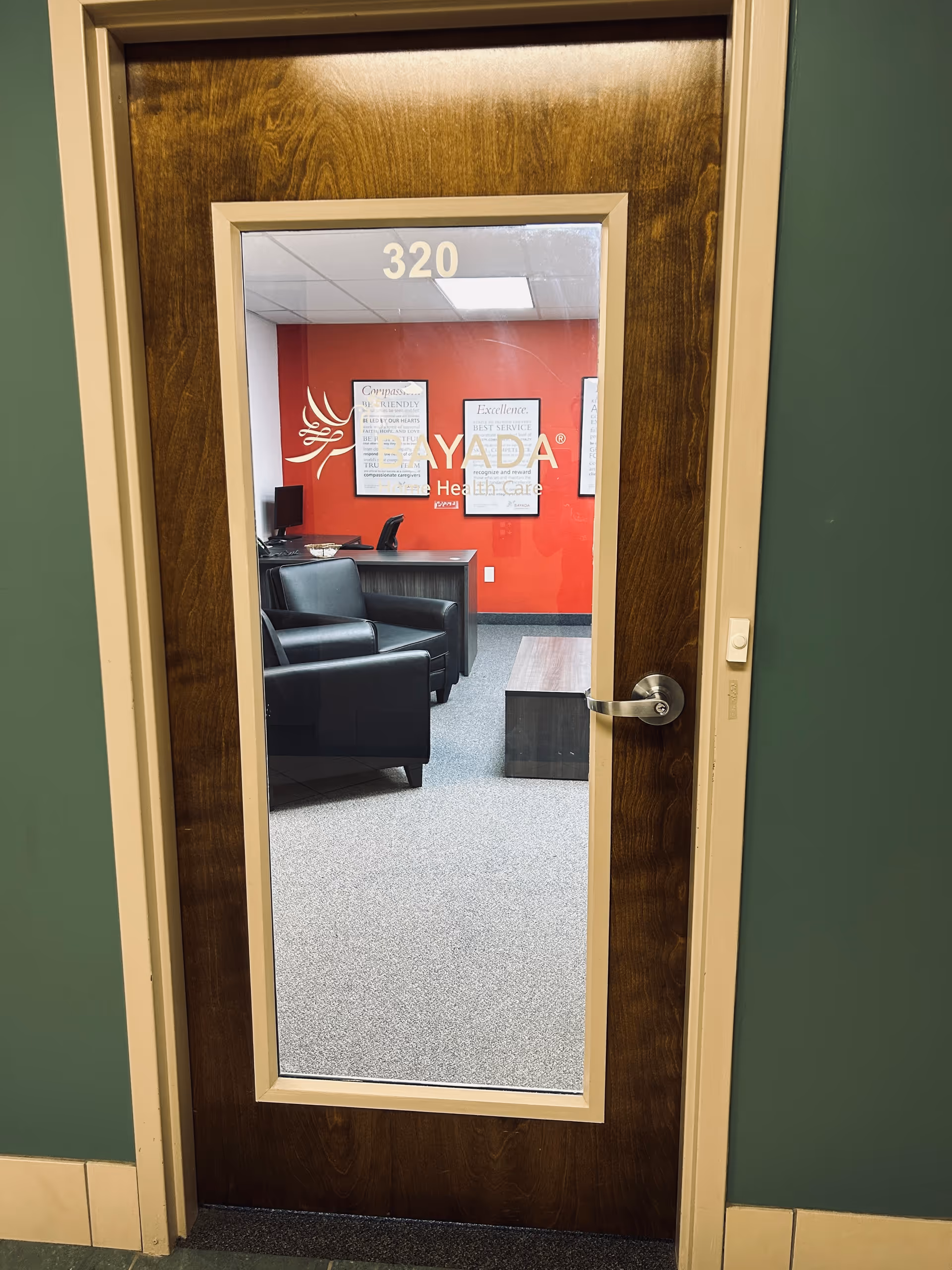 Door with BAYADA signage opens to an interior reception area with red wall.