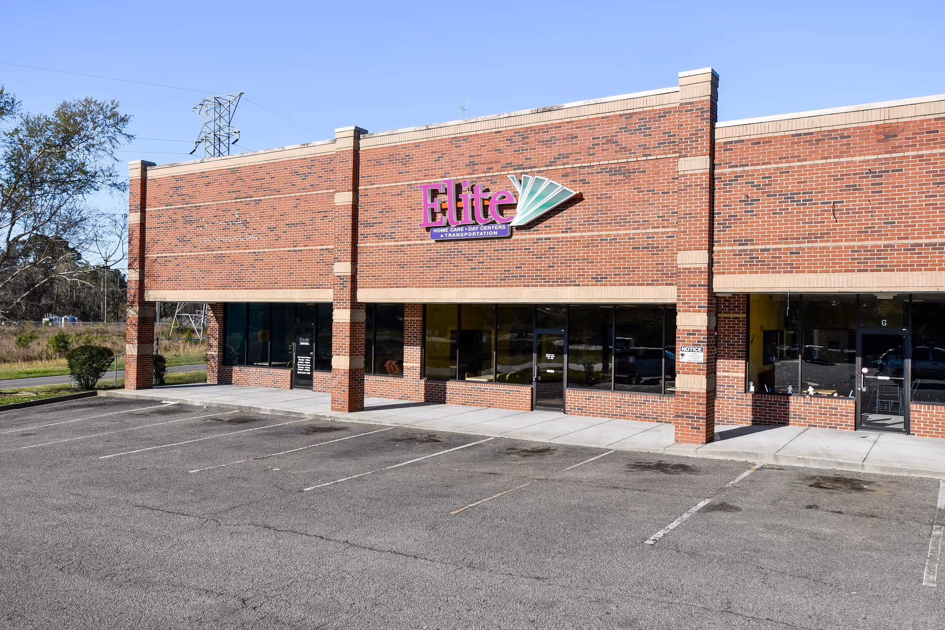 Exterior view of Elite Home Care and Day Centers storefront with brick facade and parking lot.