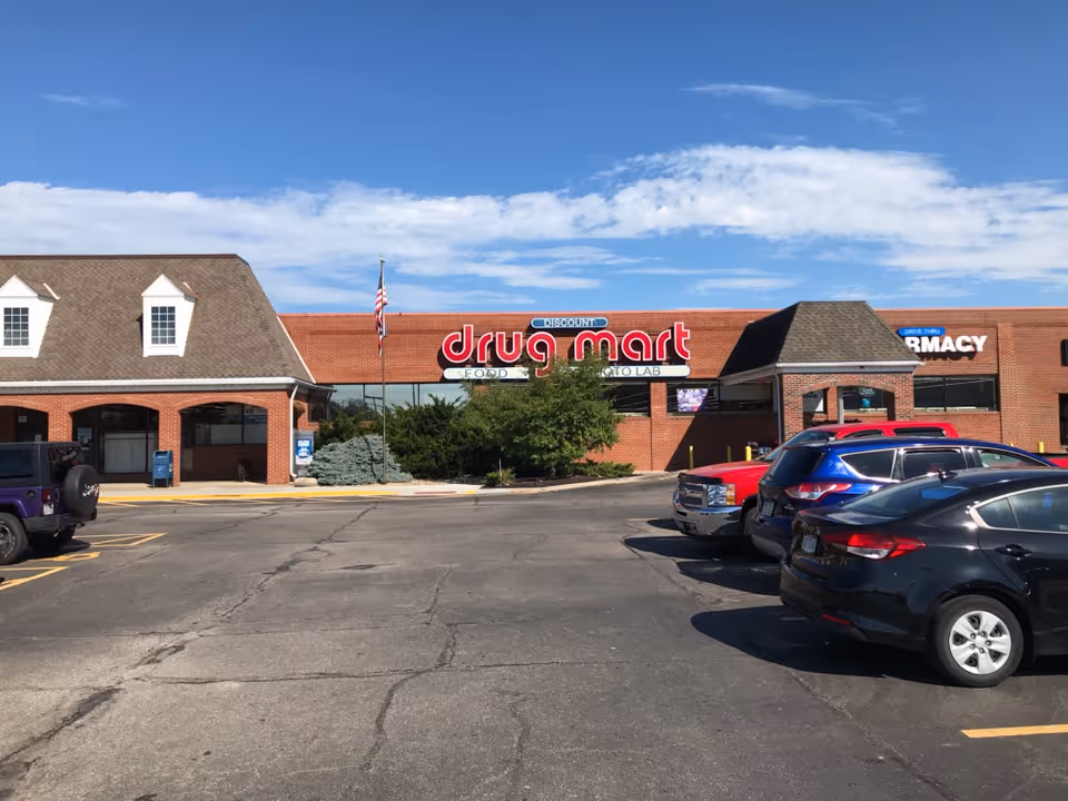 Exterior view of Discount Drug Mart storefront with a parking lot