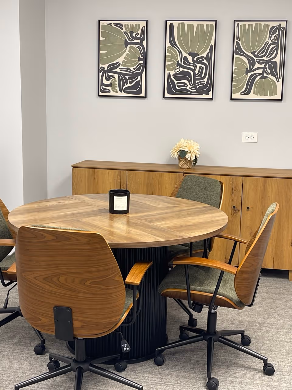Round wooden table with chairs in a bright dining area.