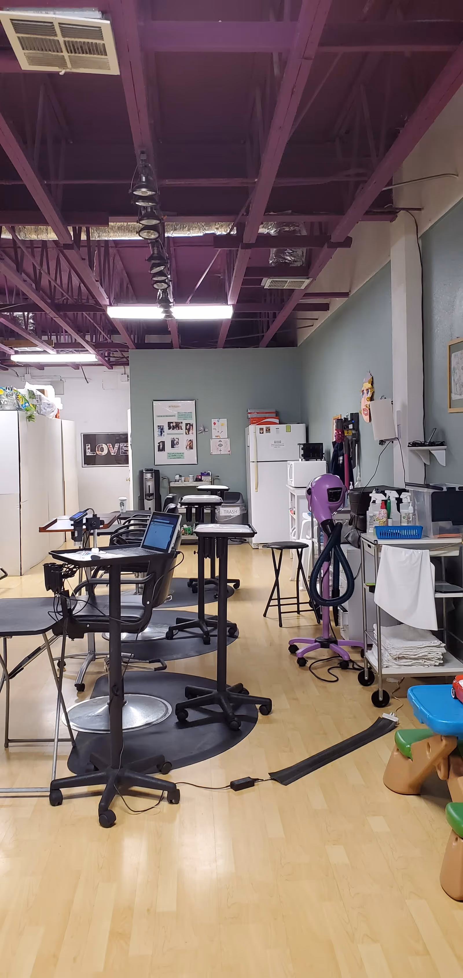 Interior room resembling a salon with chairs, equipment, and a purple ceiling.