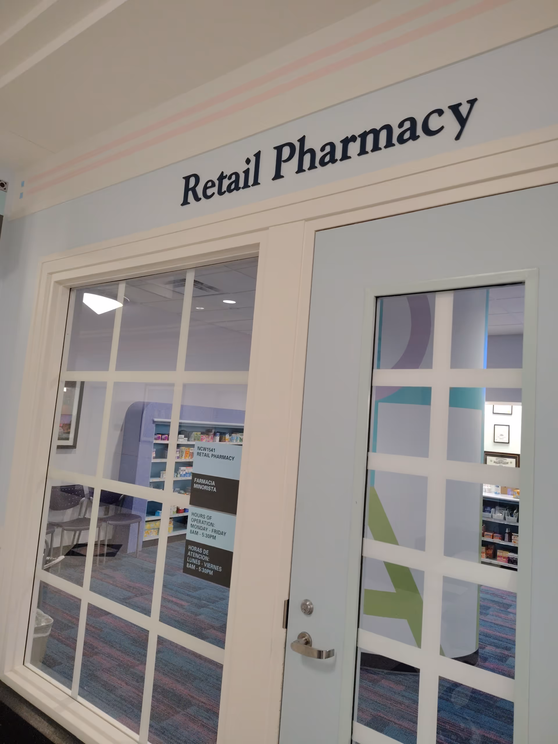Interior of a facility showing glass doors labeled Retail Pharmacy.