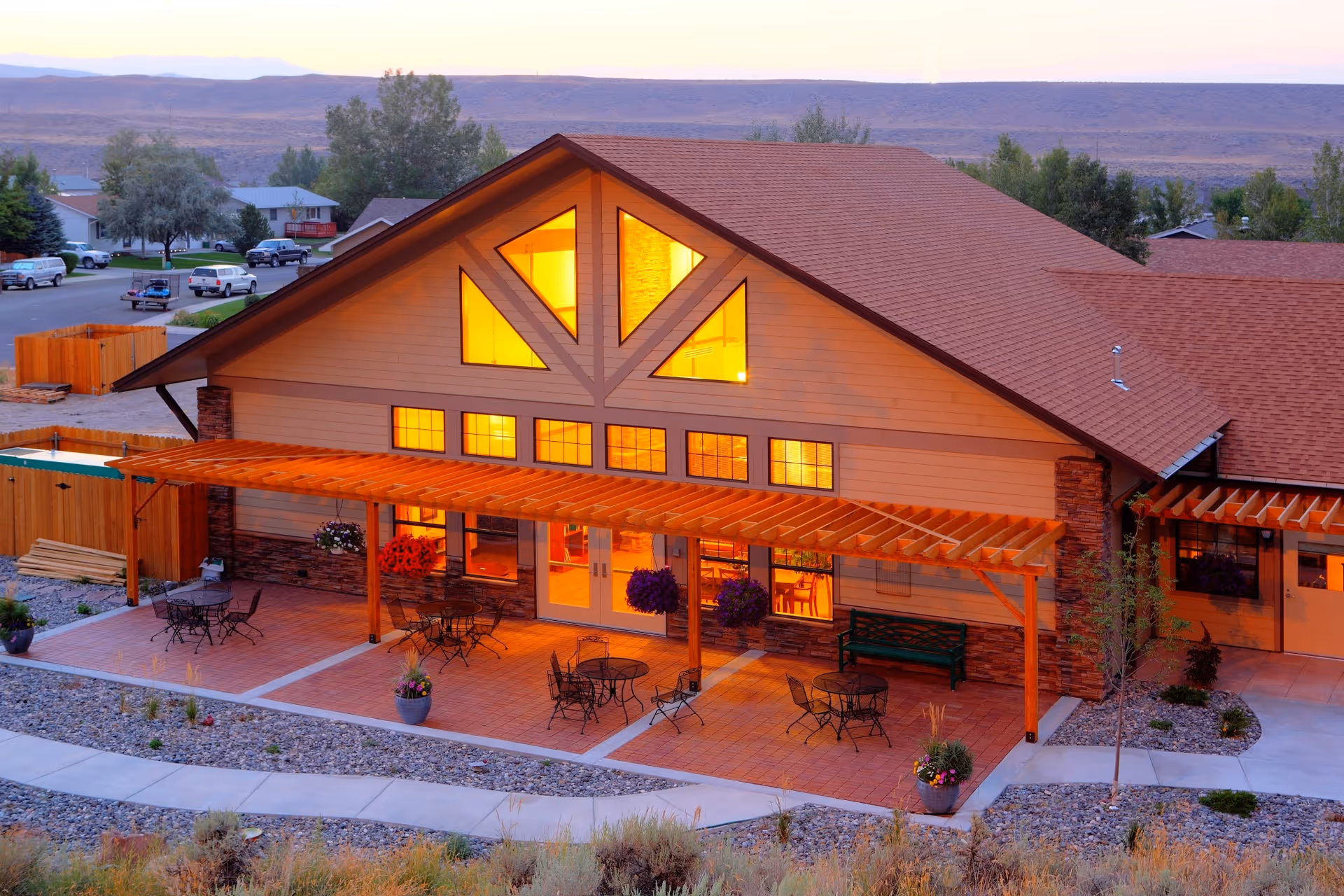 Exterior of Cody Regional Health Spirit Mountain Hospice House with lit front and outdoor patio seating.