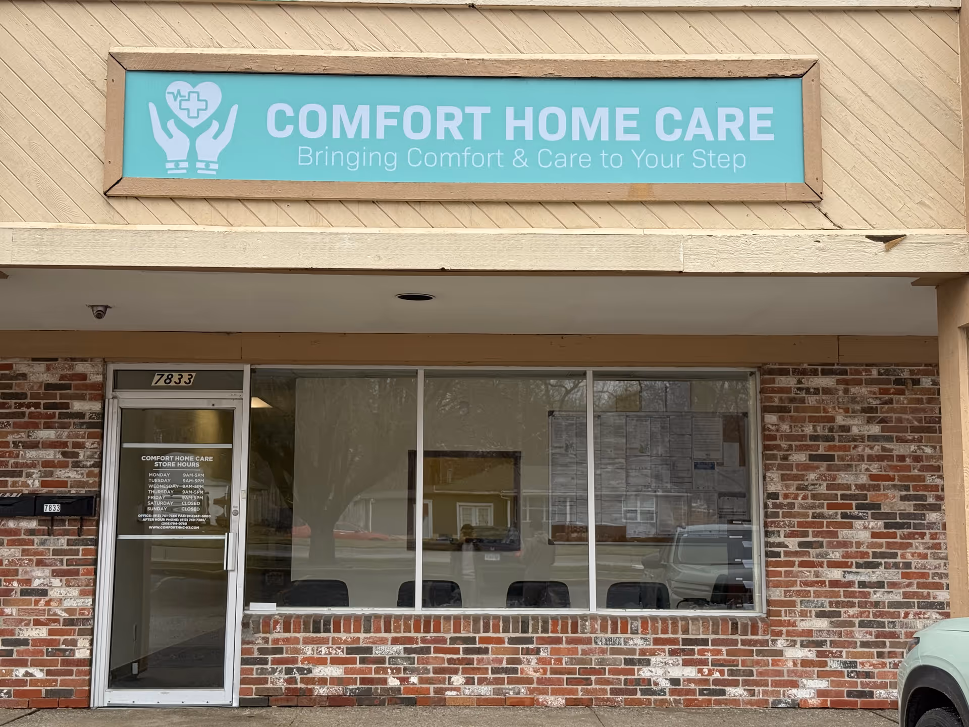 Brick storefront with Comfort Home Care sign and large glass windows