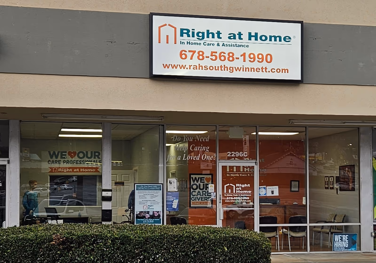 Exterior view of Right at Home storefront with sign, large windows, and visible interior.