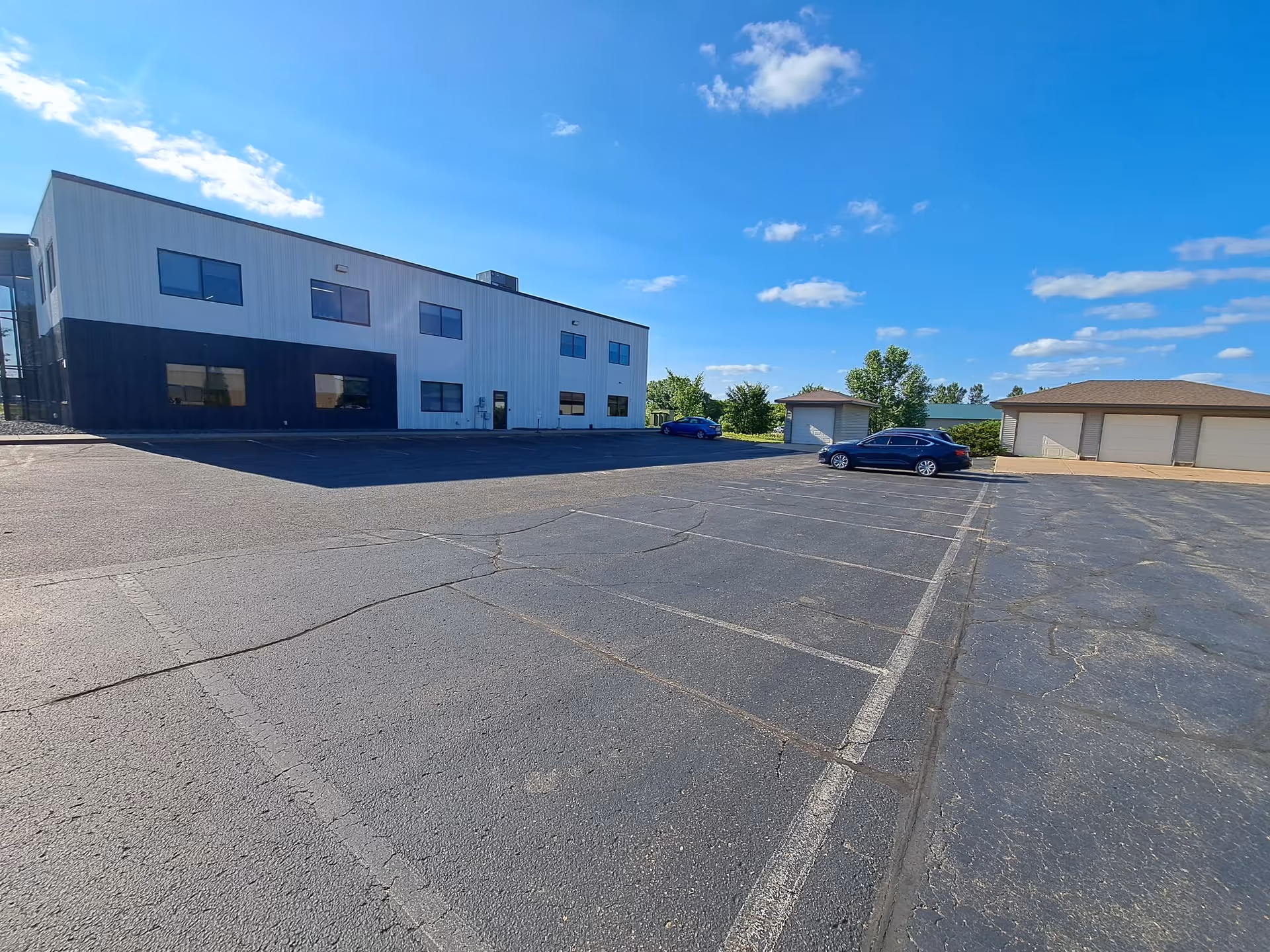 Exterior view of a modern St. Croix Hospice building with a parking lot under blue sky.