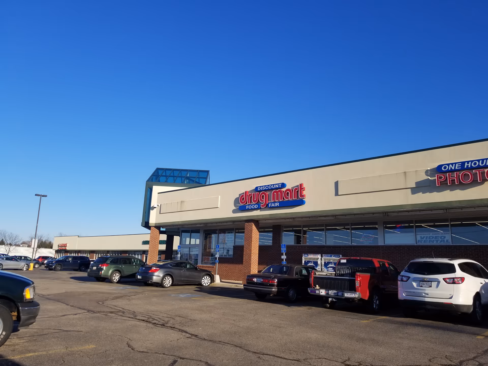 Exterior view of a Discount Drug Mart storefront with cars in the parking lot