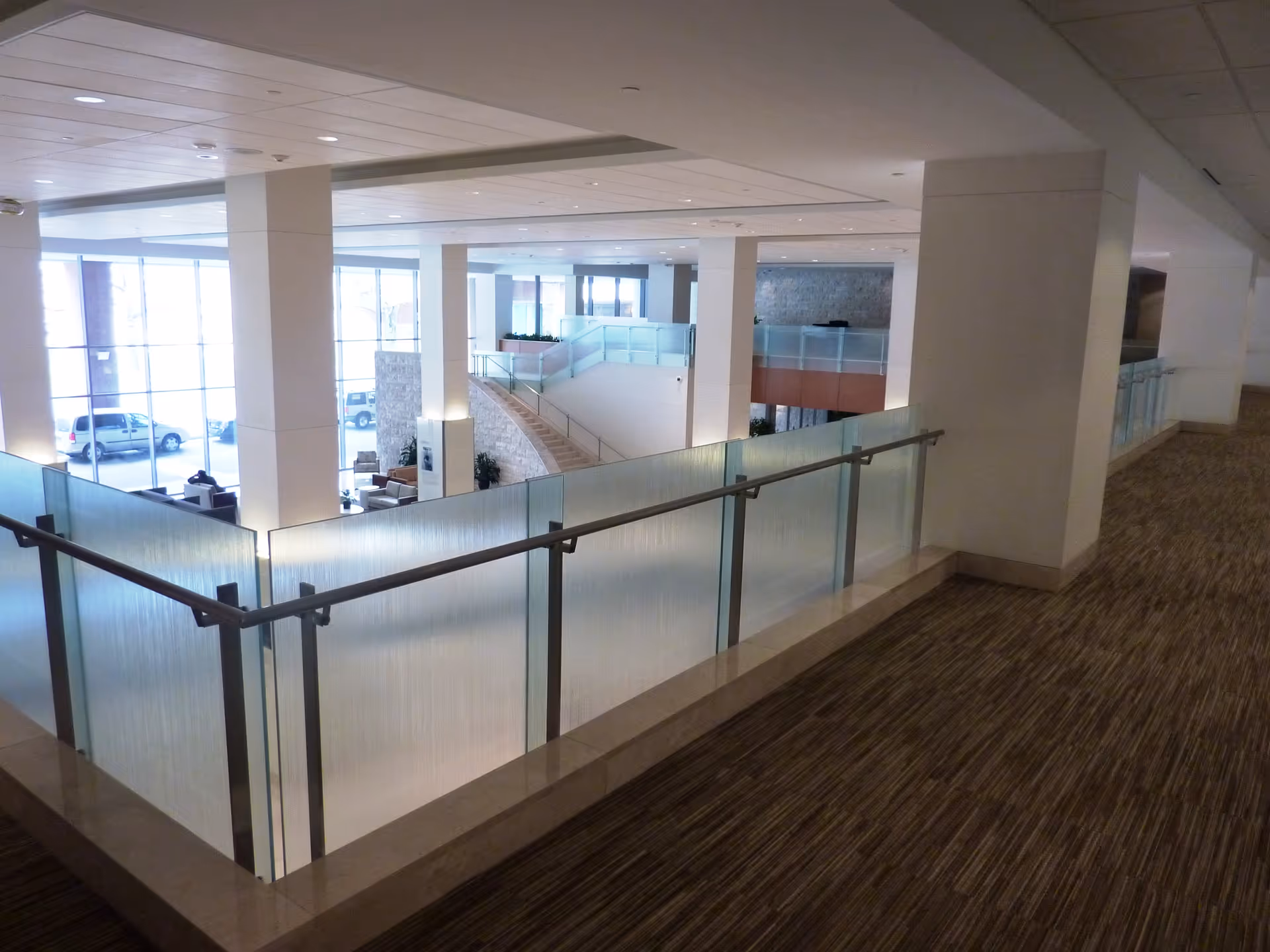 Interior atrium of Mercy Medical Center with glass railing, pillars, and open stairwell.