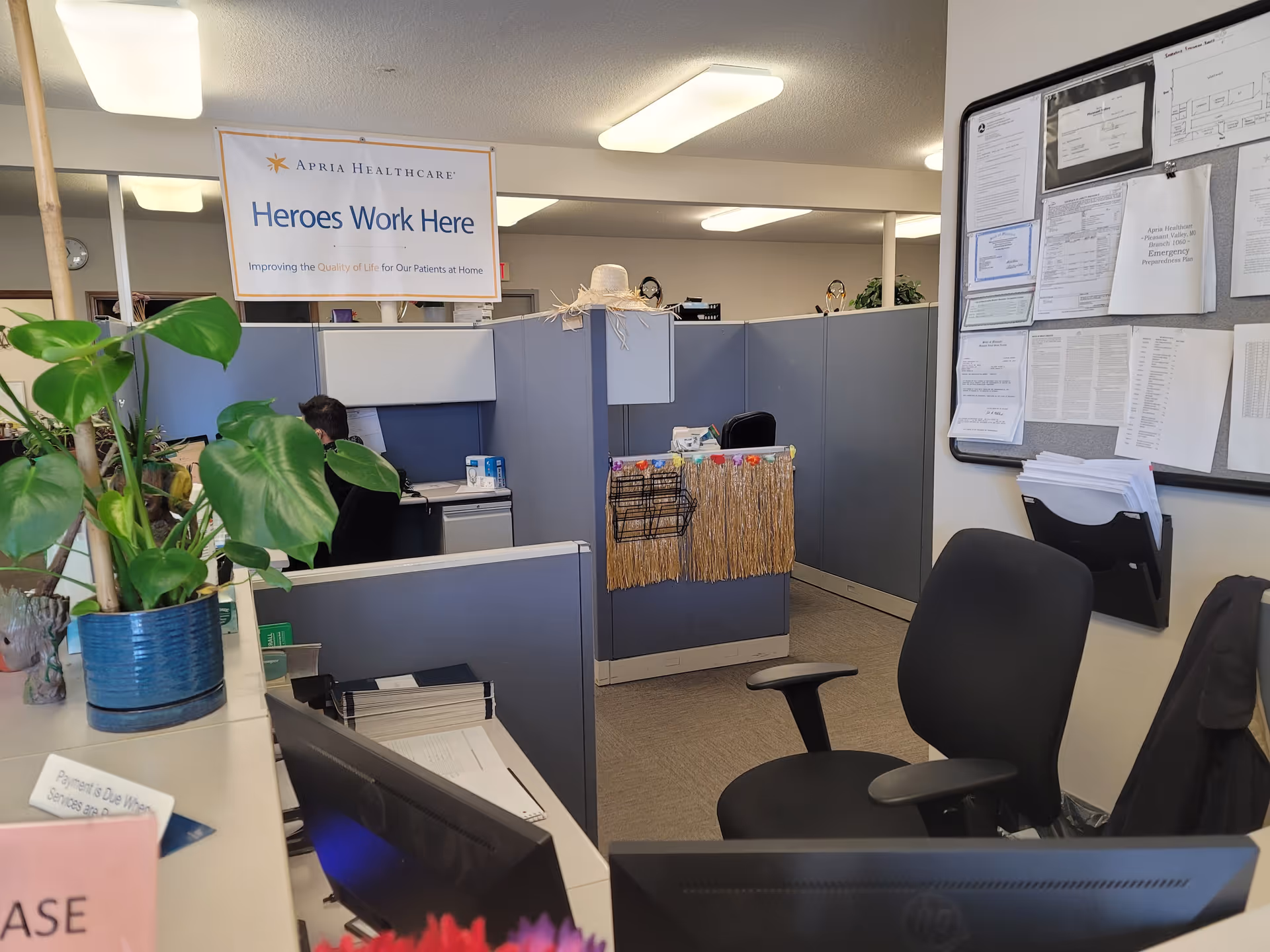 Office cubicles, a reception area, and a sign reading Heroes Work Here.