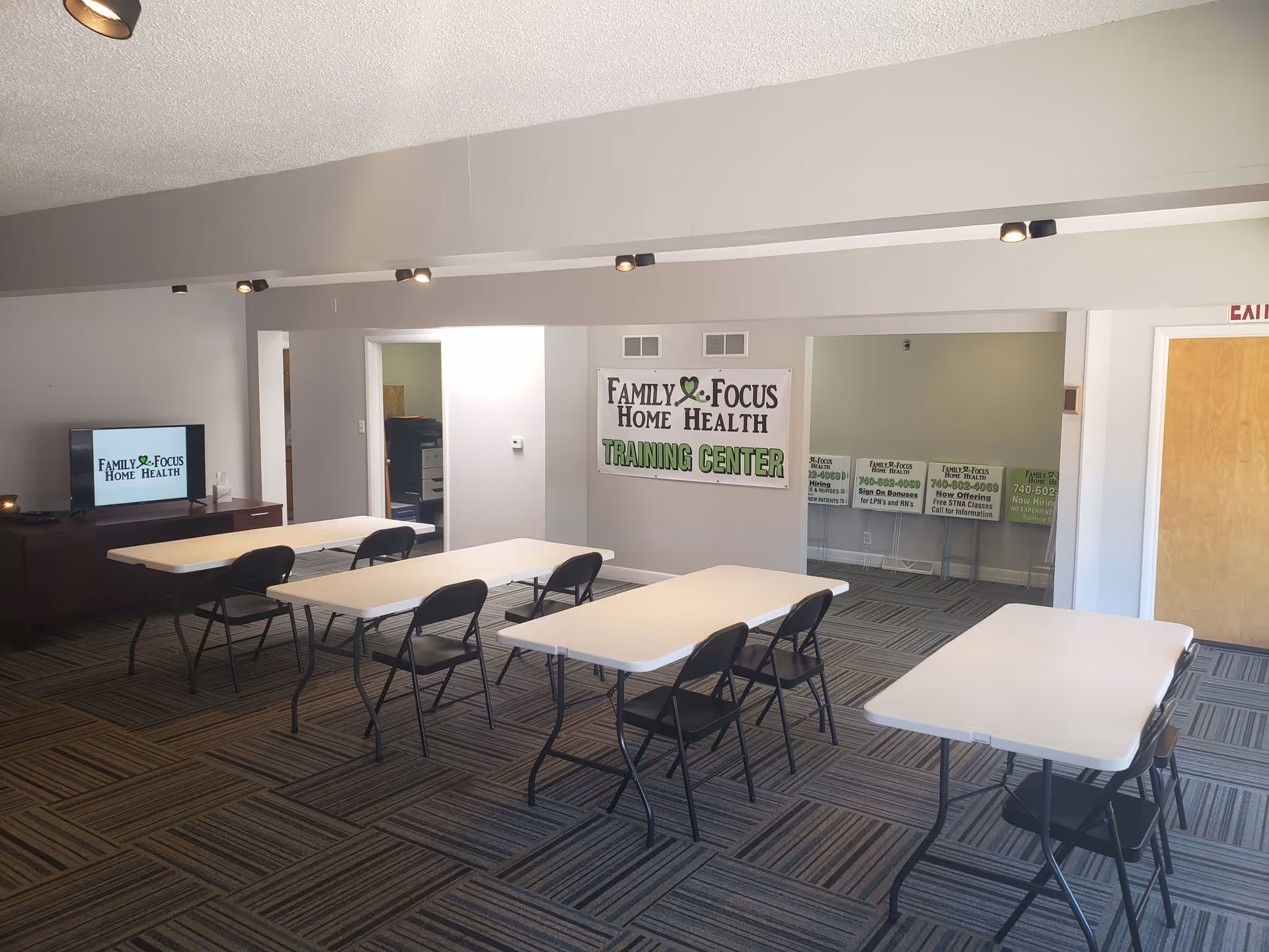 A training center room with folding tables, chairs, and a banner reading Family Focus Home Health.