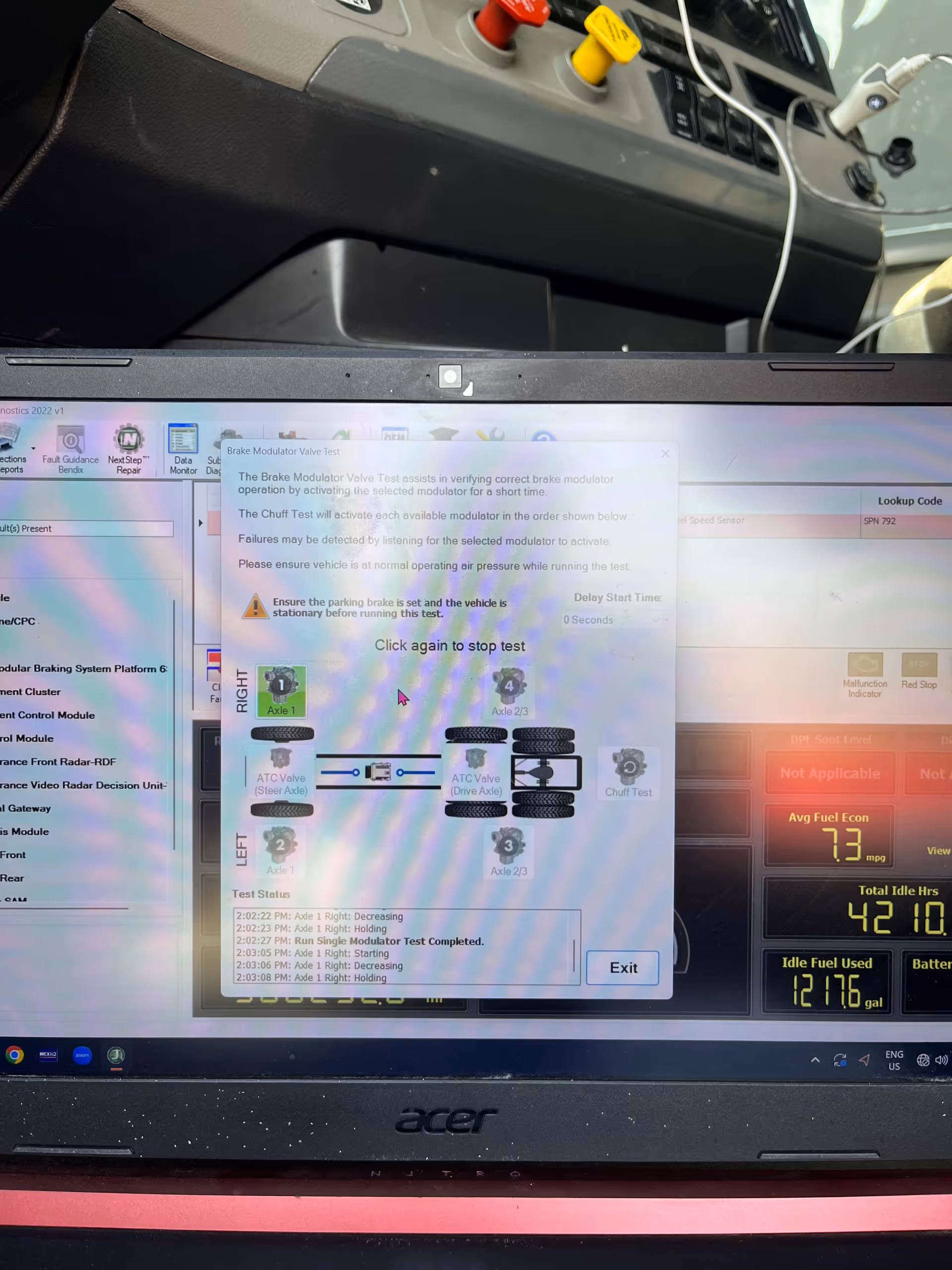 Laptop screen displays brake modulator test software with vehicle dashboard data.