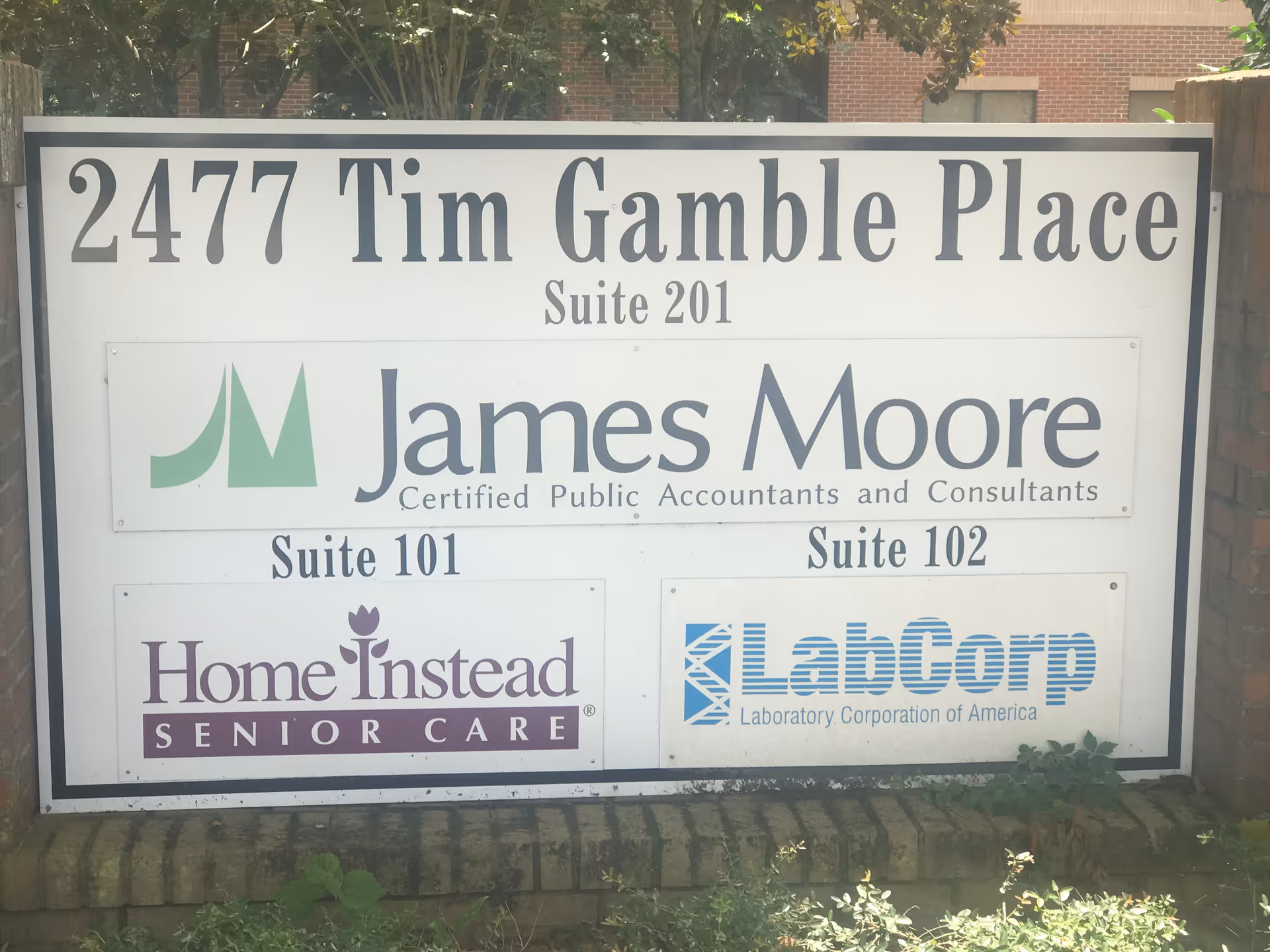 Exterior signboard displays multiple business logos, including Home Instead Senior Care and LabCorp.