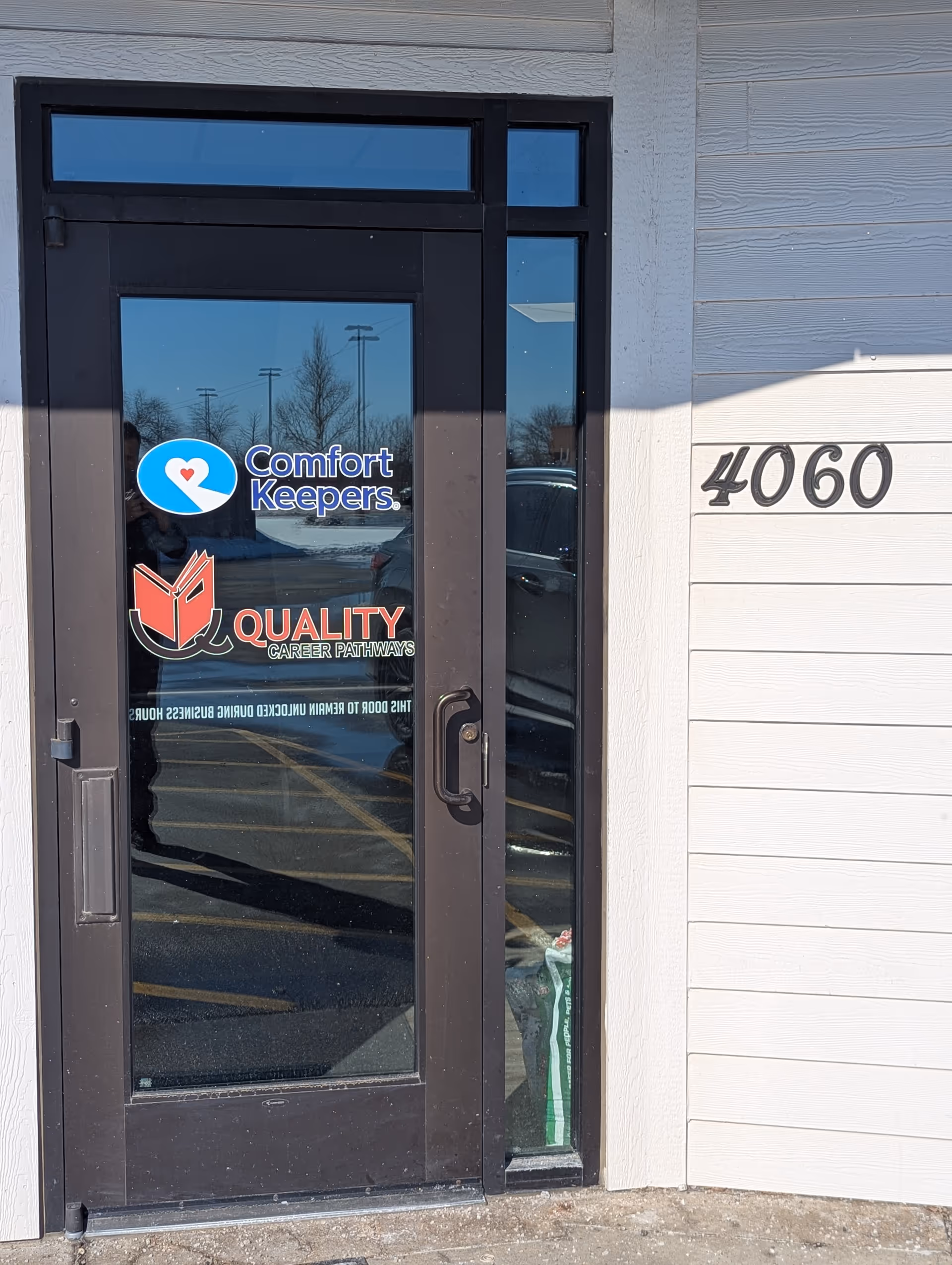Front entrance of Comfort Keepers building with glass door and address 4060.