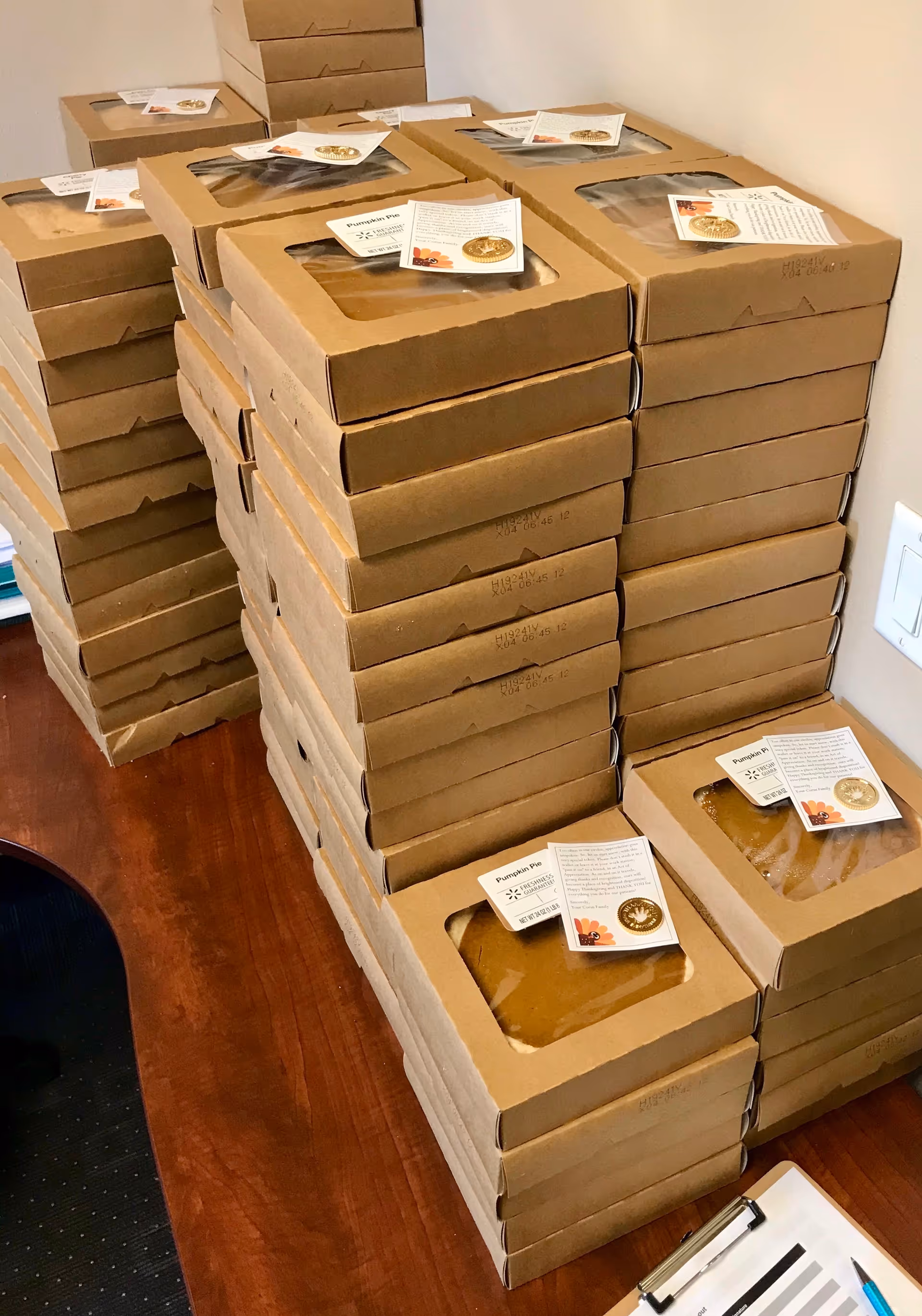 Stacks of brown cardboard meal boxes with window openings fill a storage room.