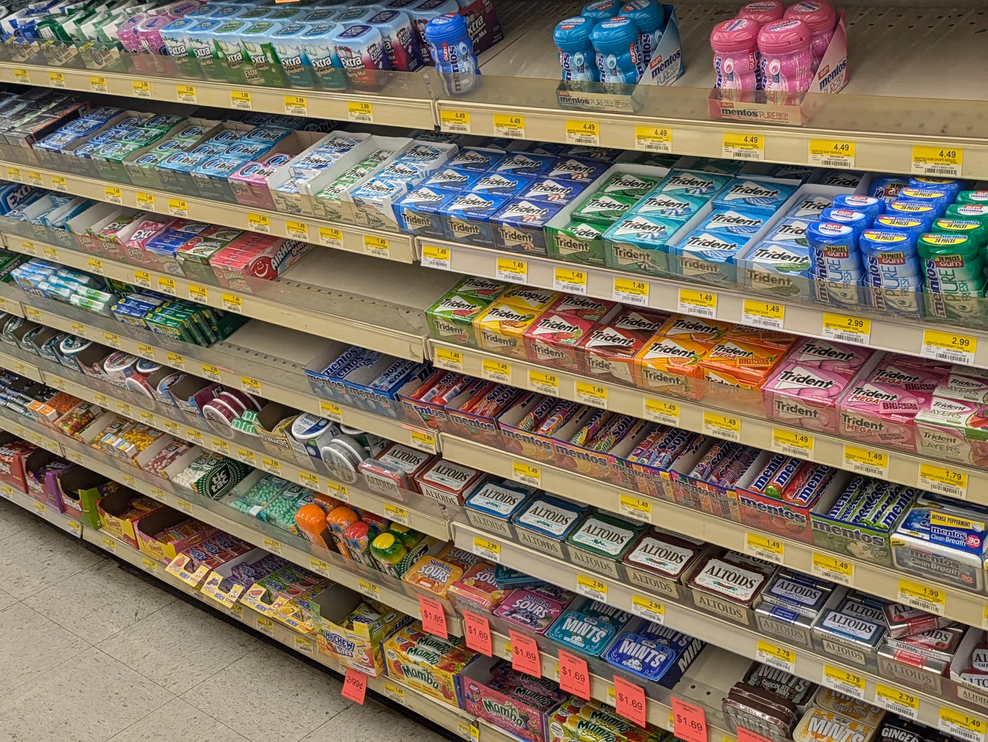 Aisle of packaged mints and gum on store shelves inside Discount Drug Mart.