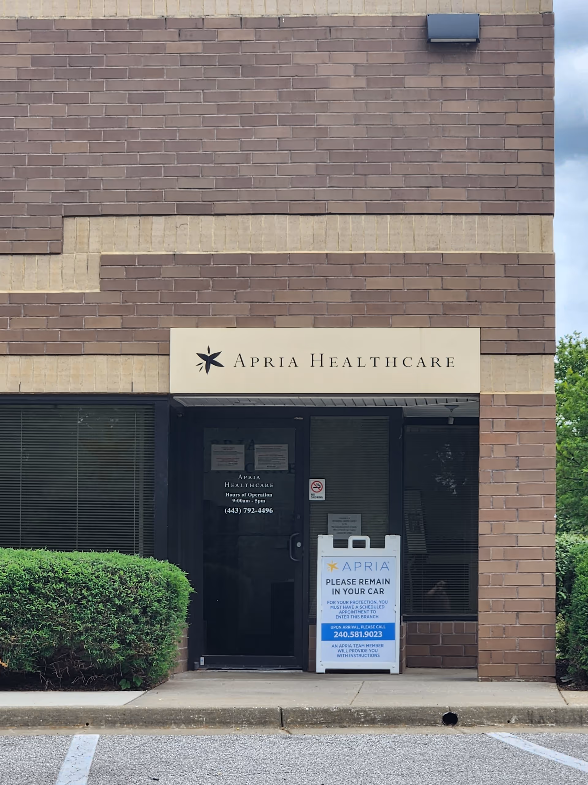 Brick facade with a glass entrance and Apria Healthcare sign above the door.