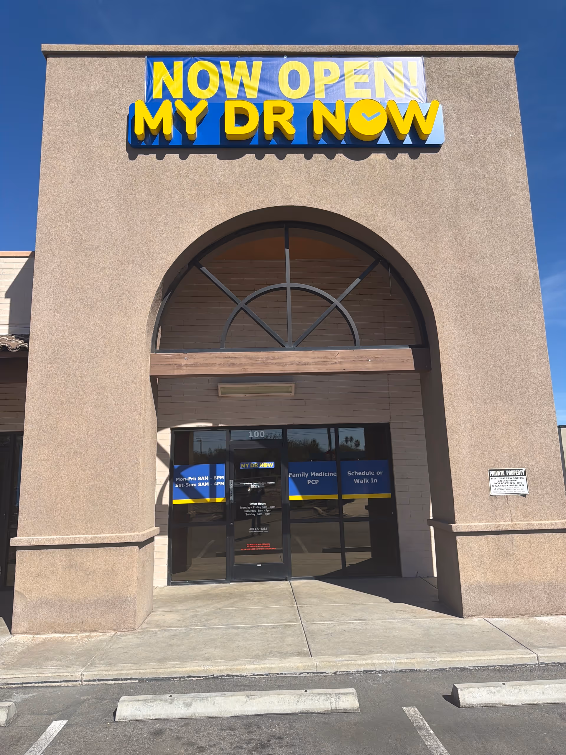 Facade of a beige building entrance with a bold NOW OPEN MY DR NOW sign.
