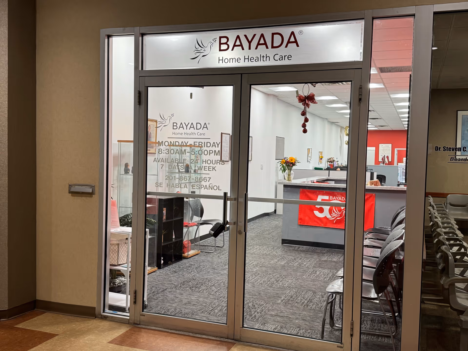 Glass doors open to BAYADA Home Health Care reception with chairs inside.