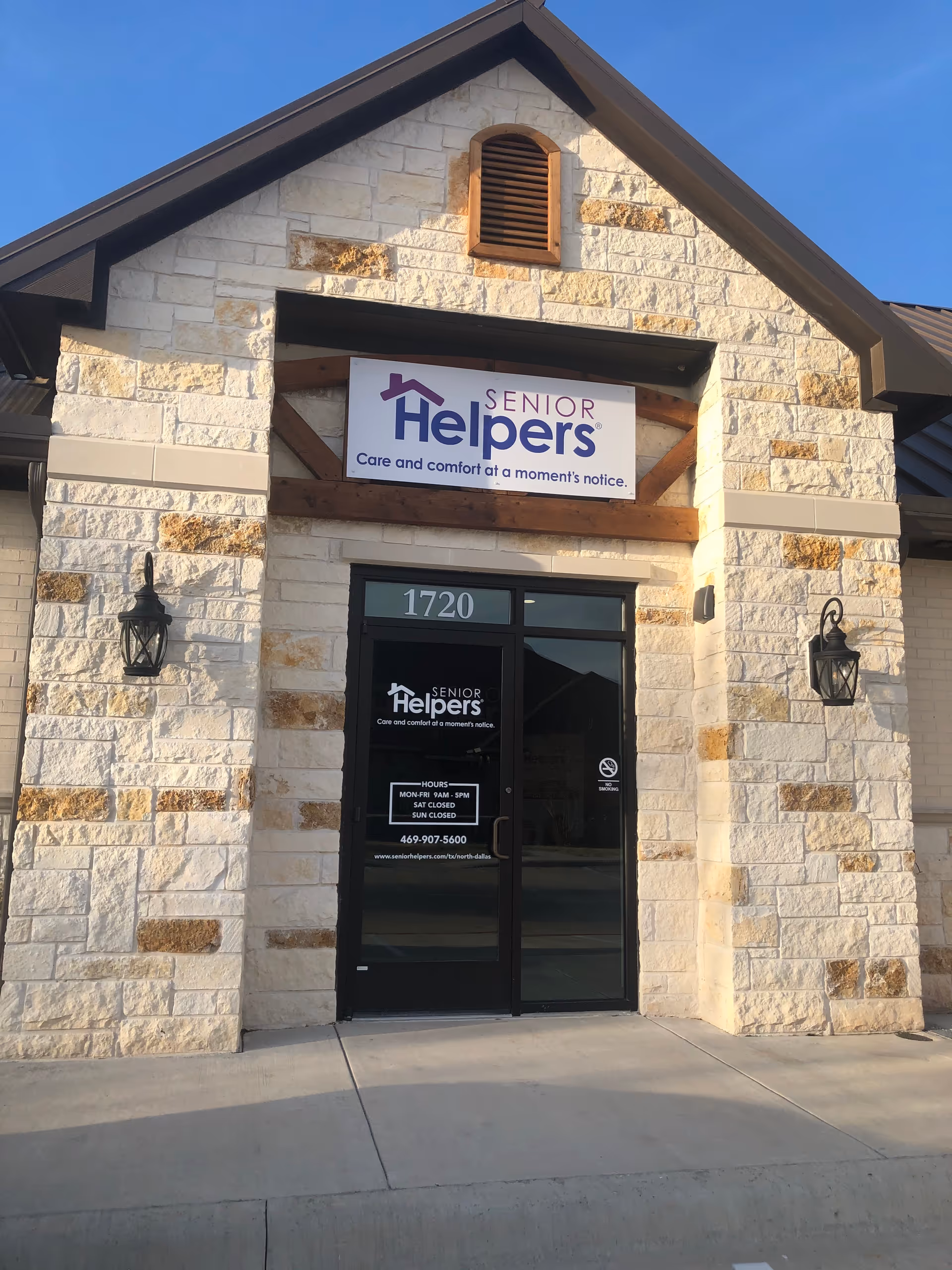 Stone building front with a Senior Helpers sign above the door.