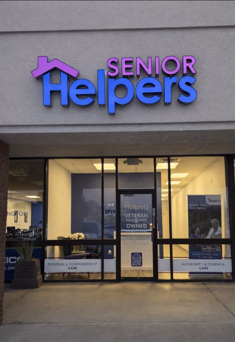 Exterior storefront of Senior Helpers with large purple and blue sign over glass entry.