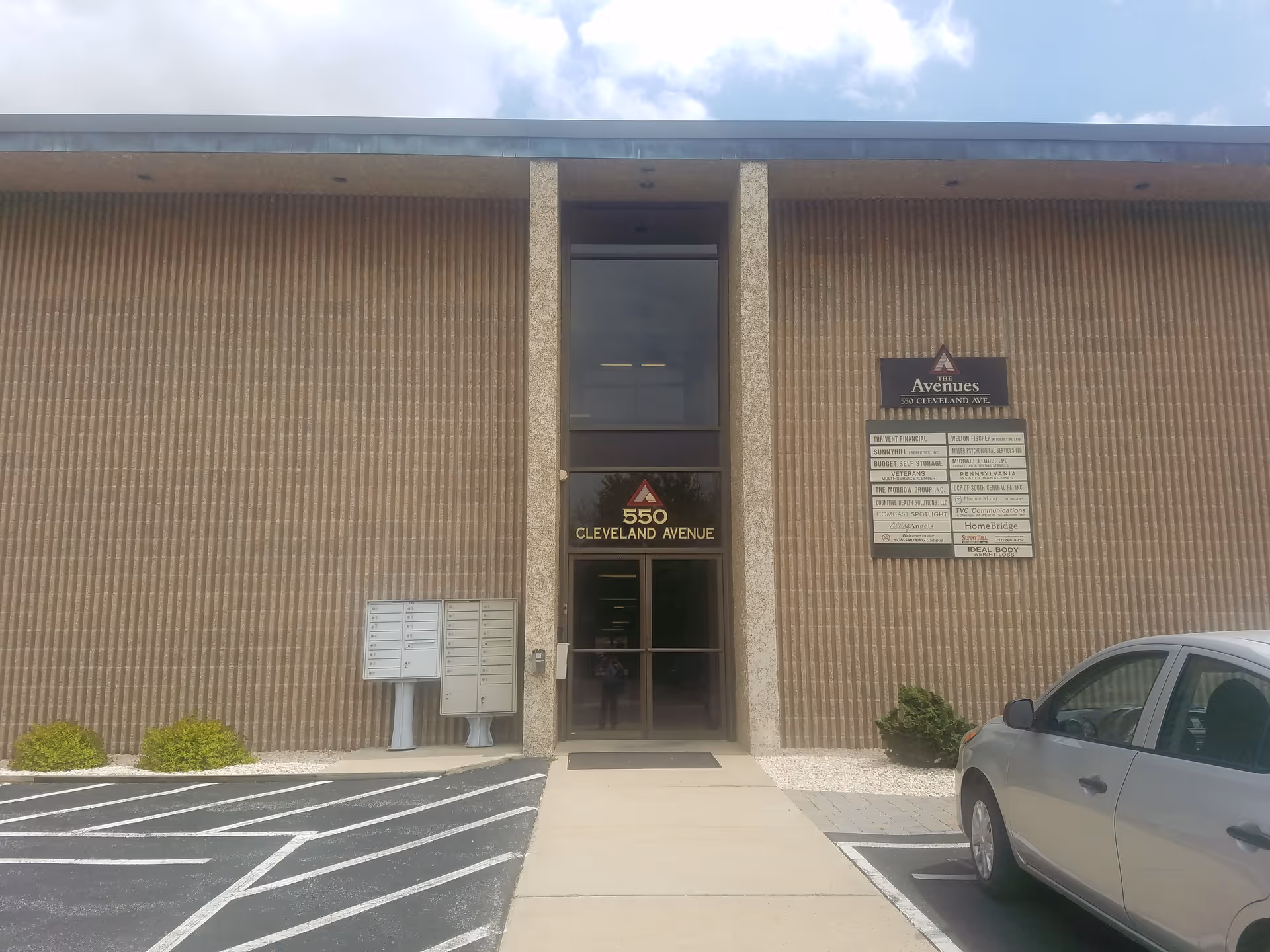Exterior view of Visiting Angels Senior Home Care building with glass entrance and parking lot.