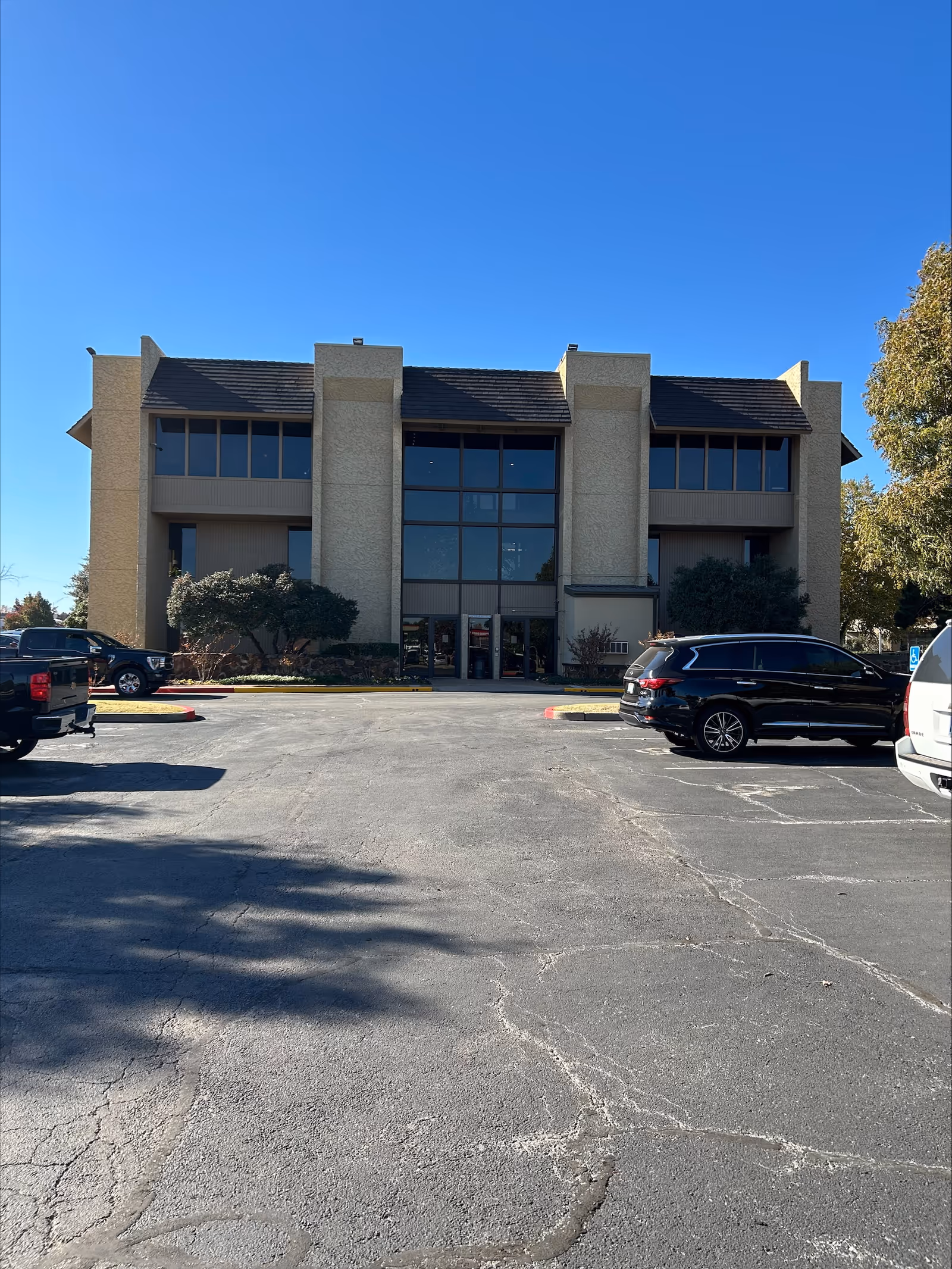 Front view of a BrightStar Care building with a parking lot under a clear blue sky.