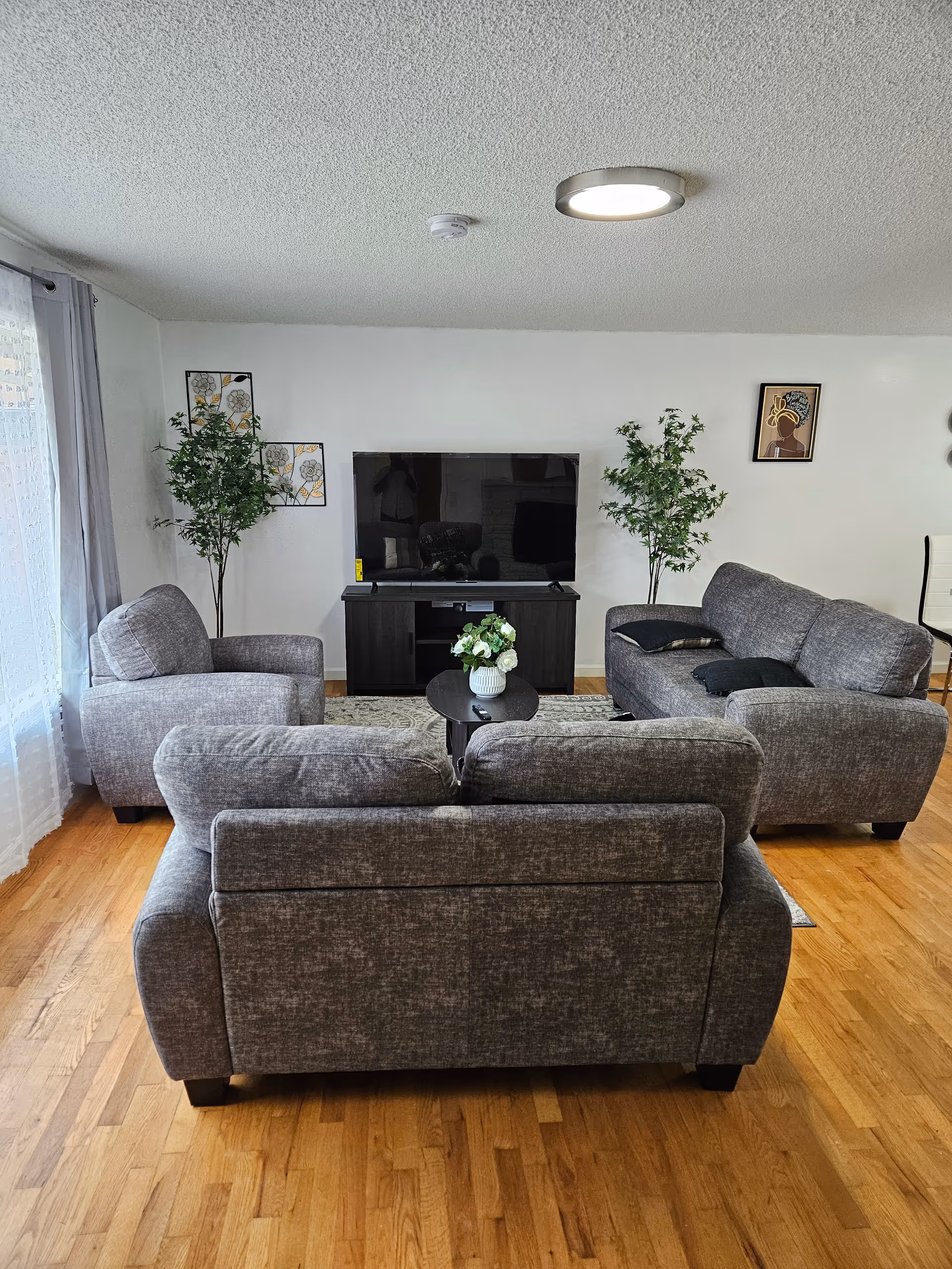 Grey sectional seating surrounds a TV in a cozy common living room.