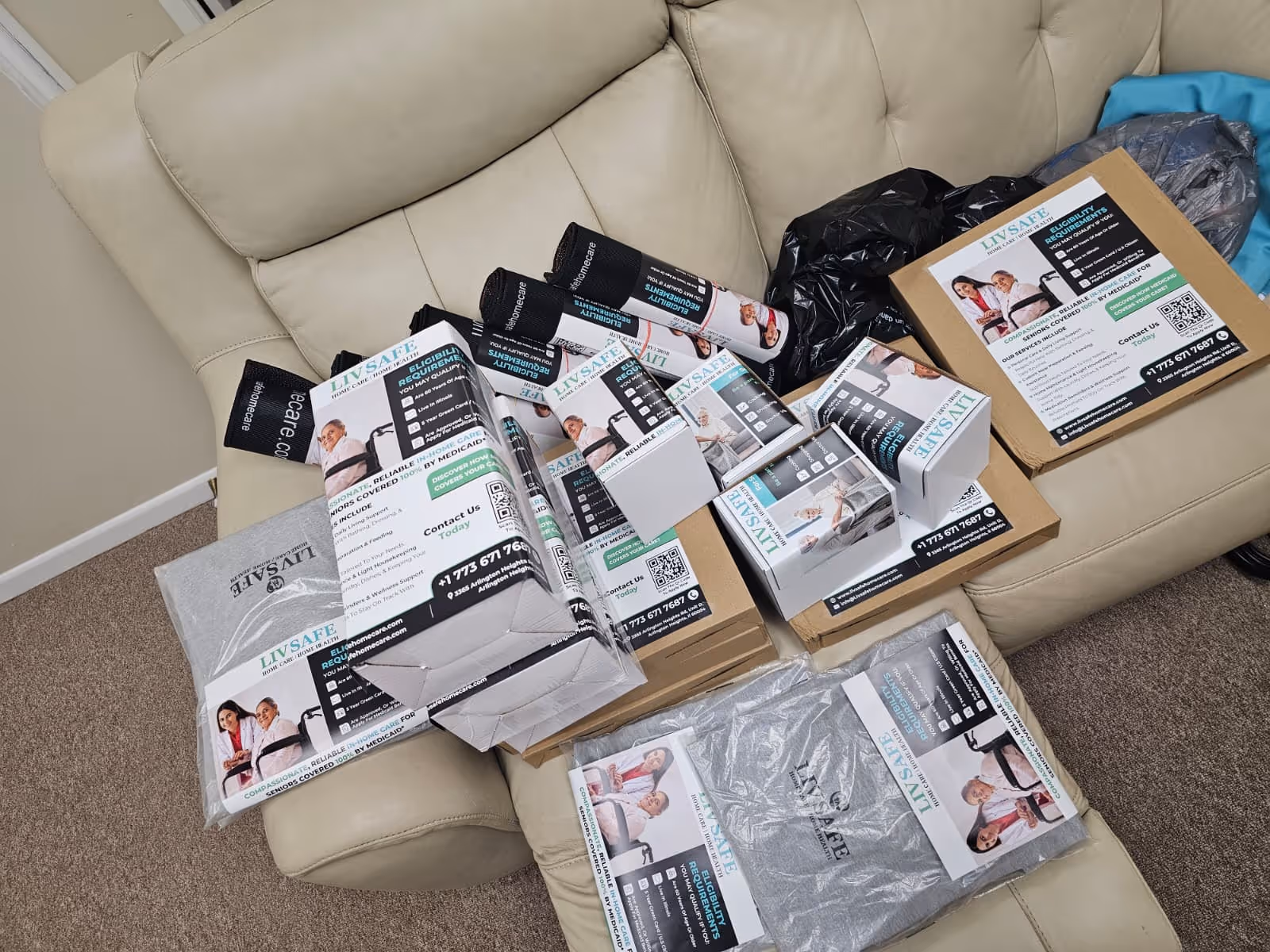 Beige living room sofa piled with LivSafe Home Care flyers and boxes