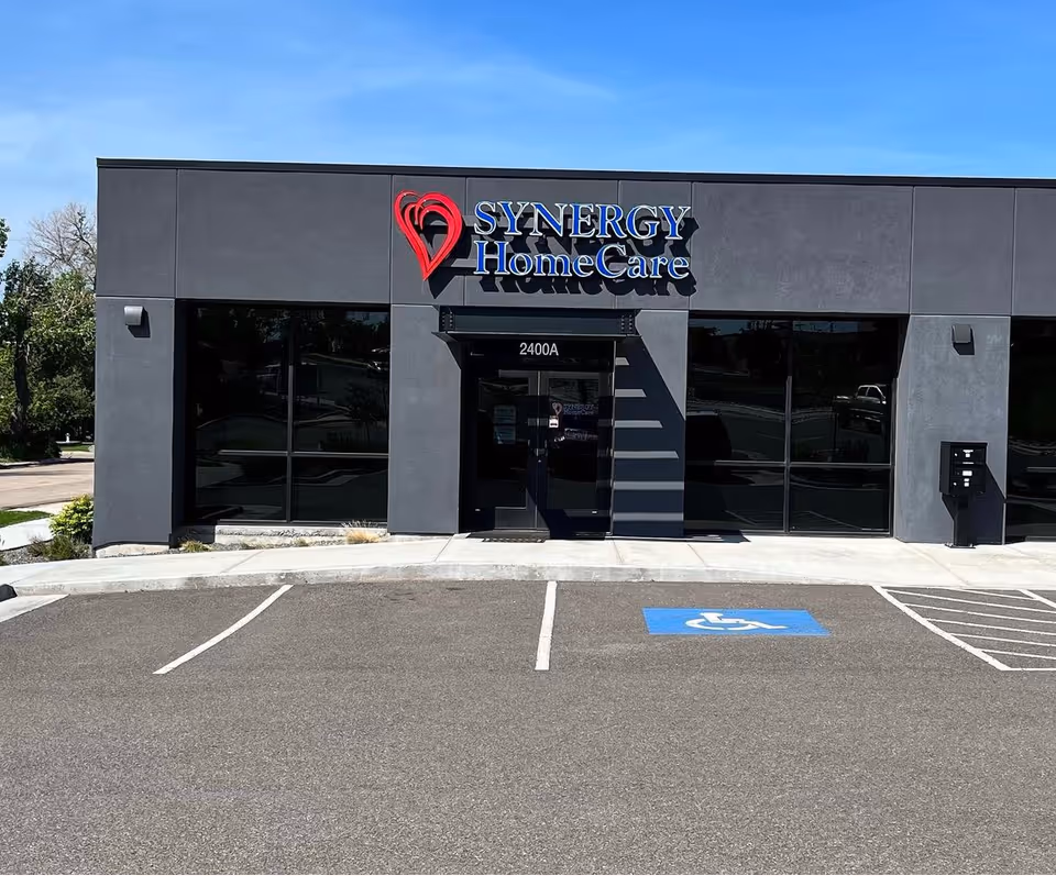Front exterior of SYNERGY HomeCare building with large windows and handicapped parking