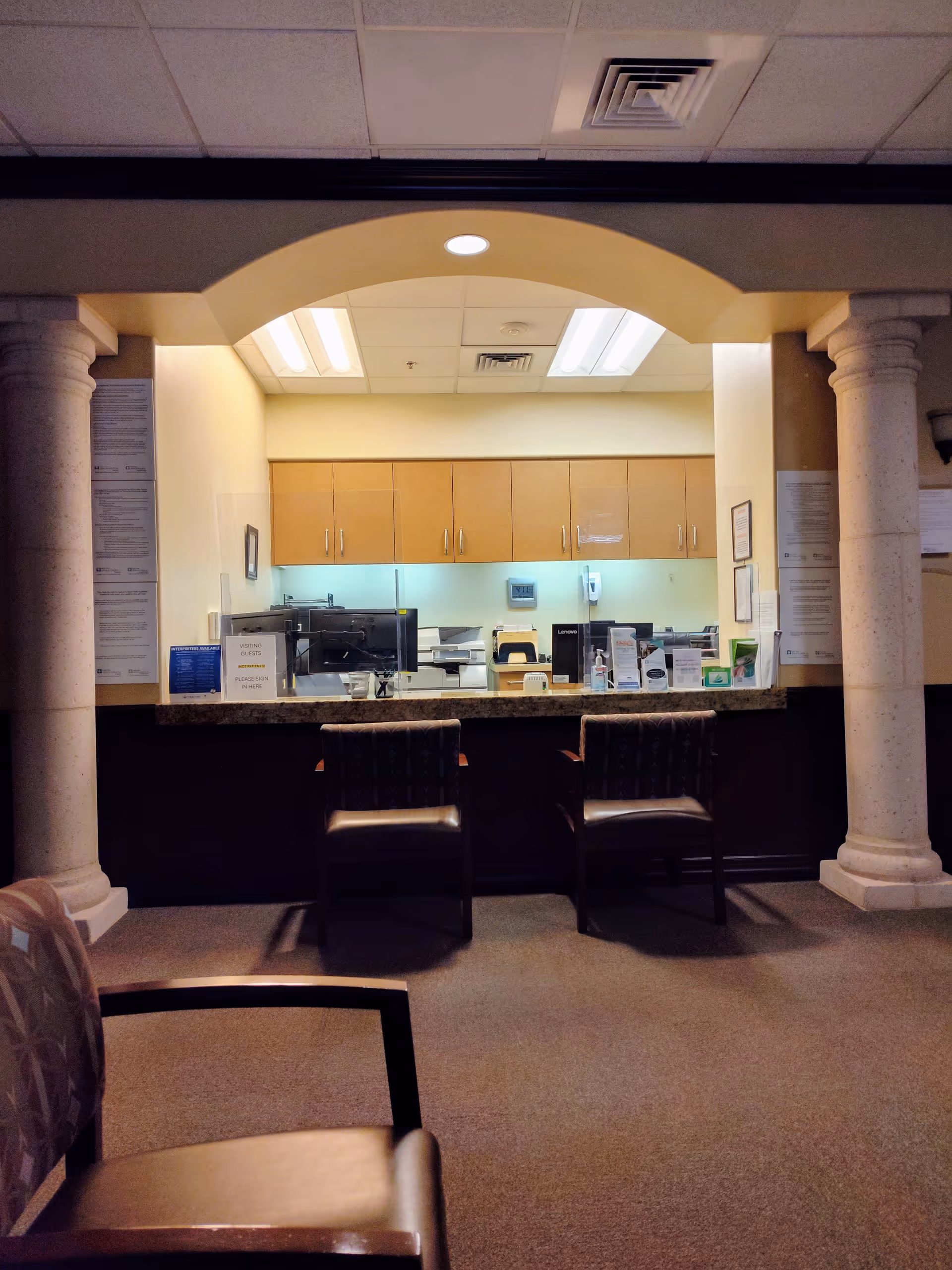 Reception area with curved arch, columns, and front desk.